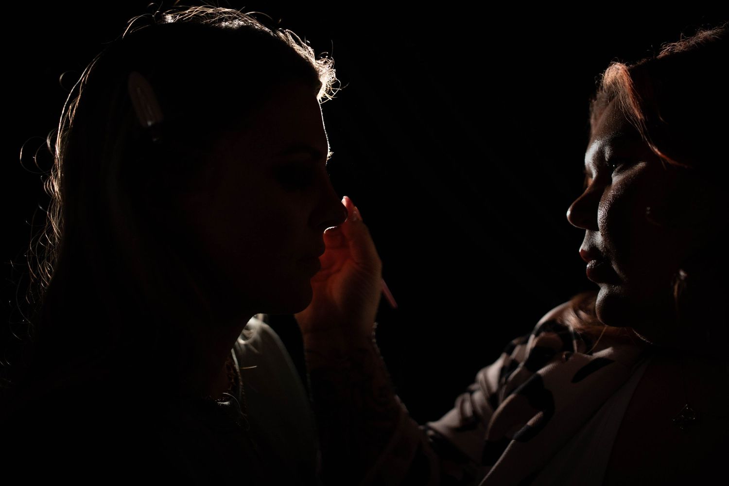 Dramatic silhouette portrait series with warm rim lighting creating a mysterious mood.