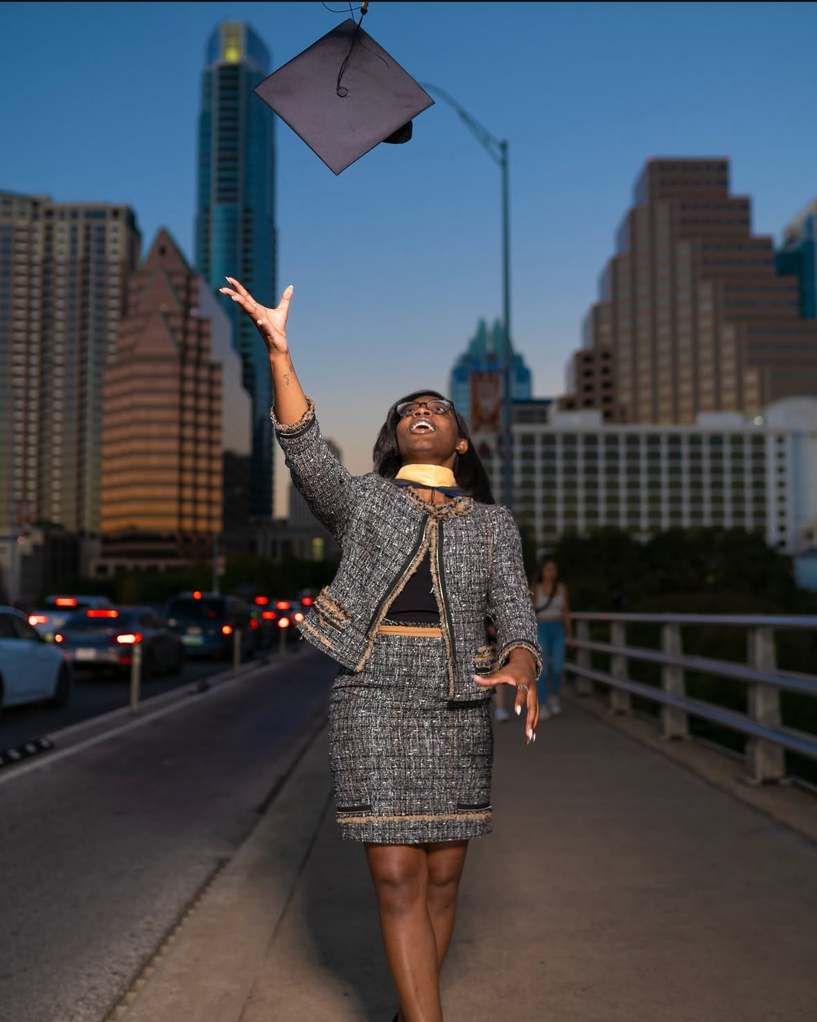 College graduate posing with cap and gown in downtown Austin, TX.