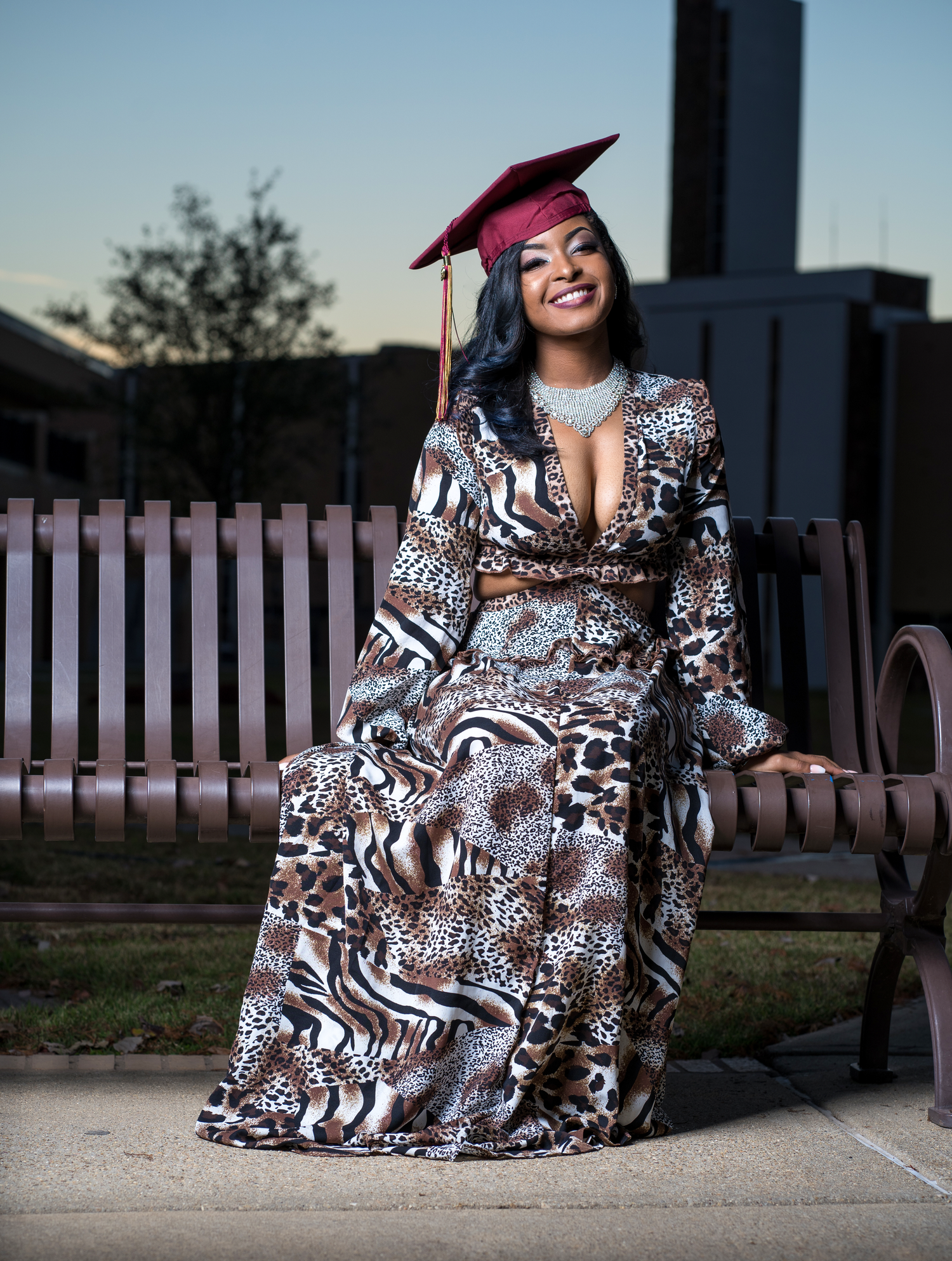 College graduate posing with cap and gown in downtown Austin, TX.