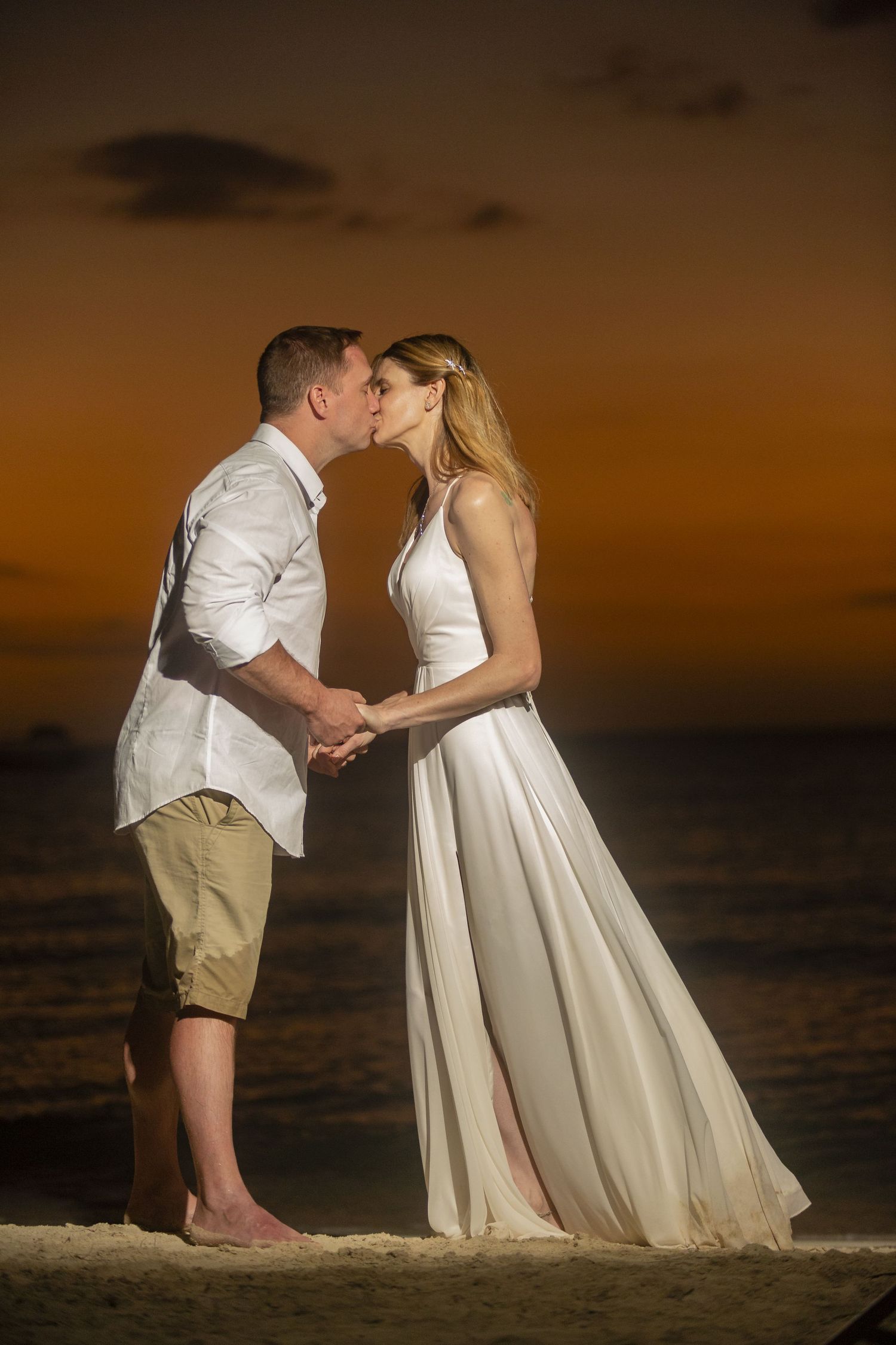 A wedding couple shares an intimate moment at sunset on Negril beach.
