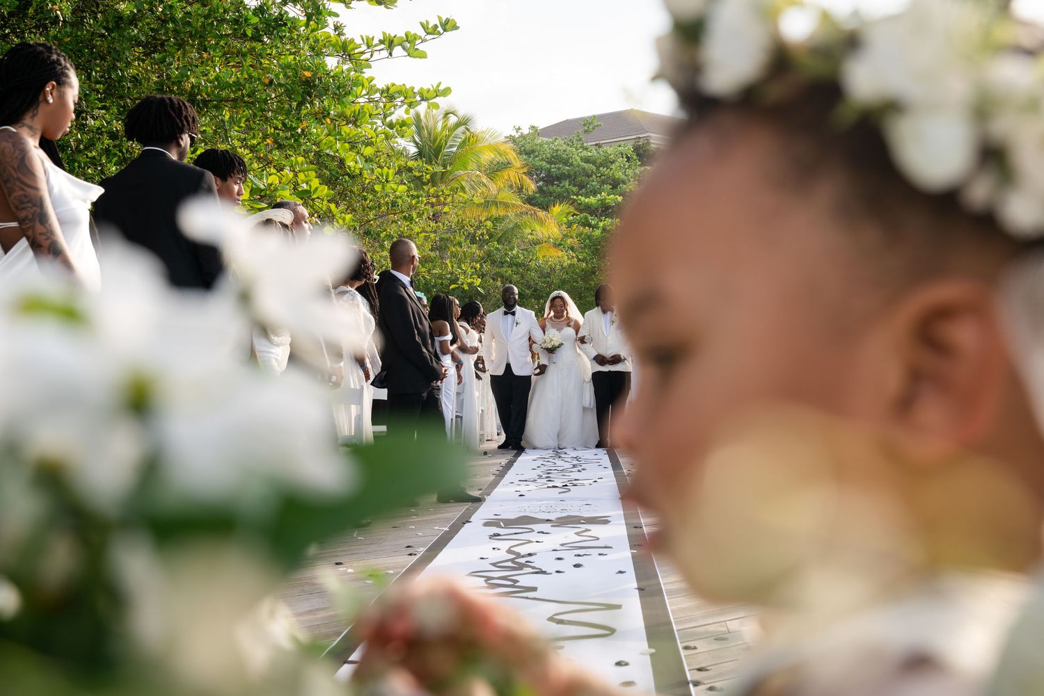 Elegant outdoor wedding setup with white floral arrangements and decorations in a natural garden setting.
