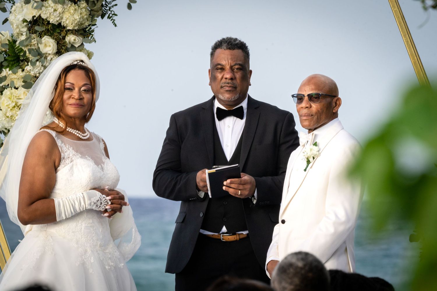 Wedding ceremony participants gathered at a beachside venue with ocean views.