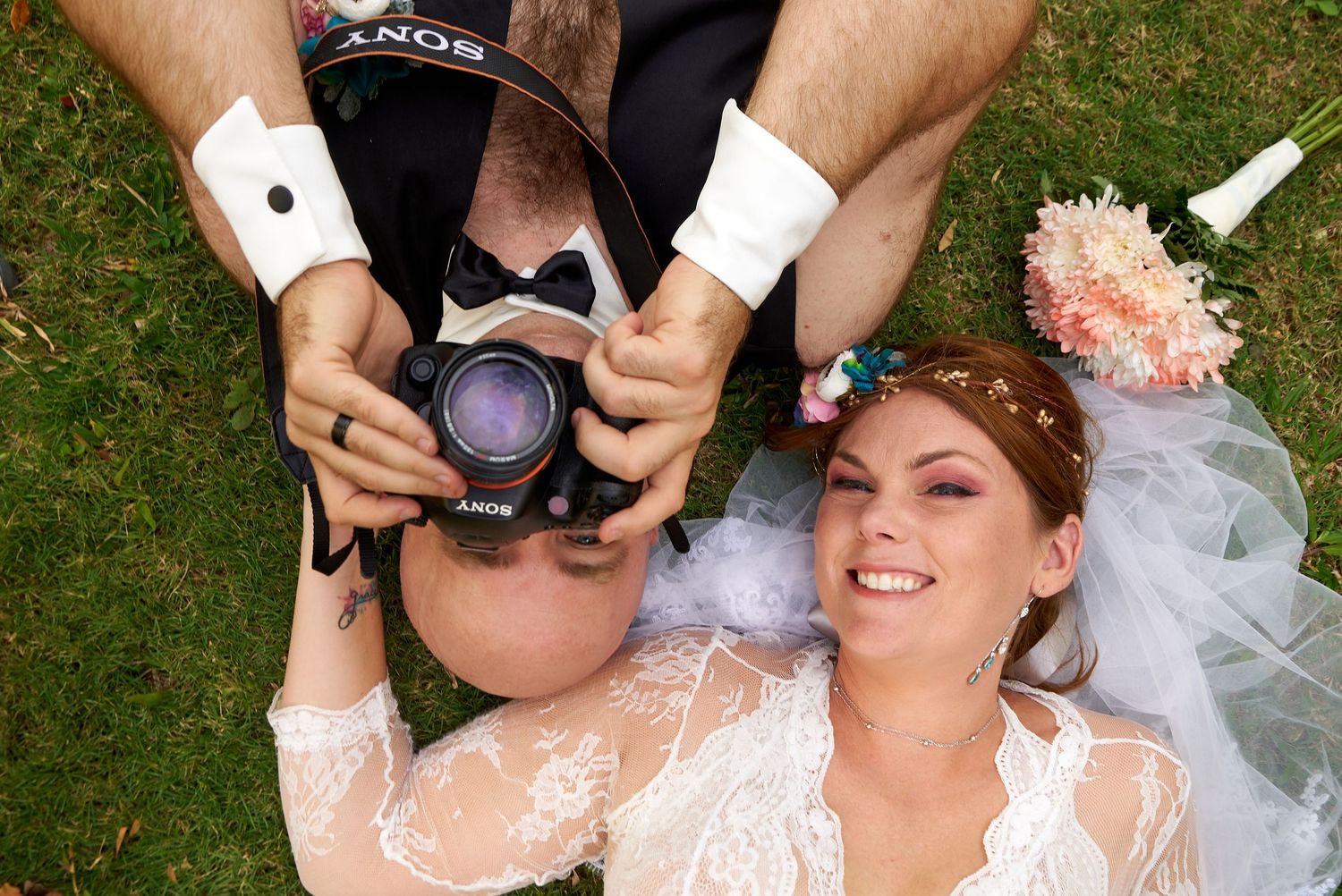 Creative ground-level photography equipment and wedding dress detail shots on grass.
