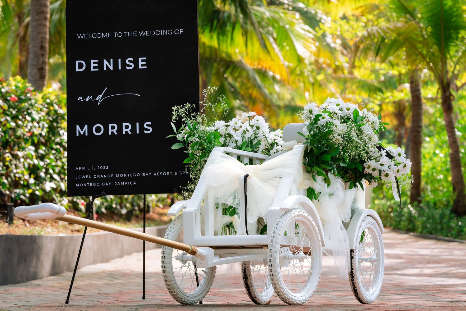 Modern wedding venue setup with white chairs and tropical palm trees creating an elegant outdoor atmosphere.