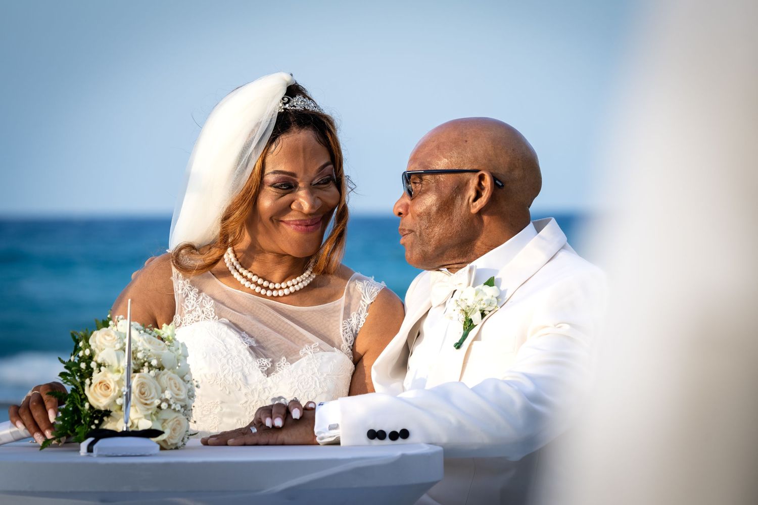 A romantic beach wedding scene with the waves of the ocean in the background.