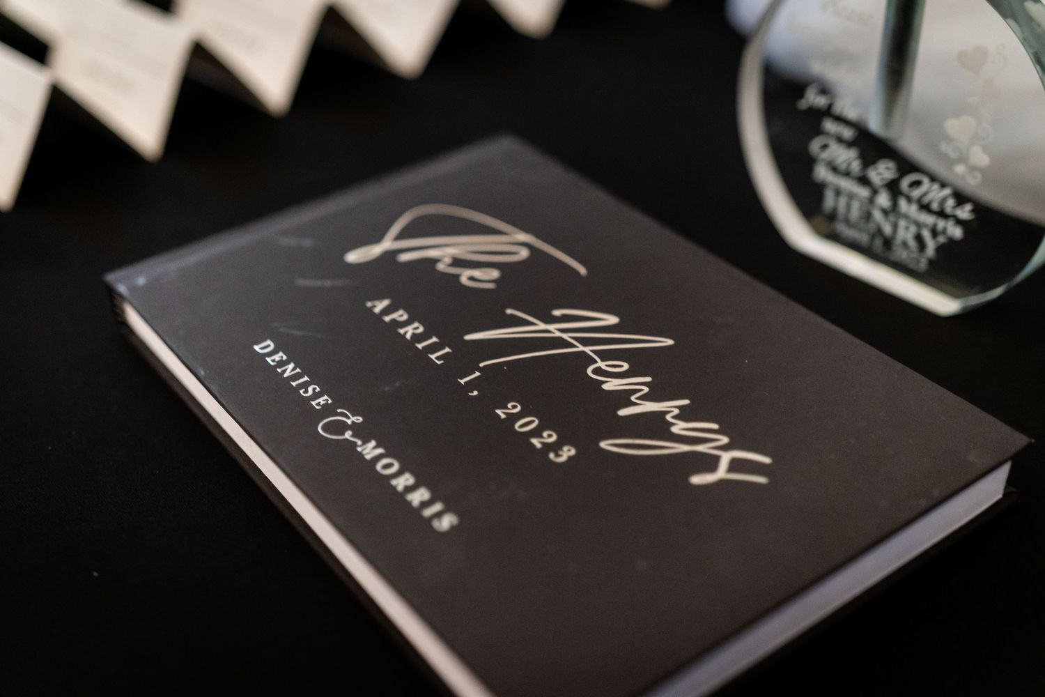 An elegant collection of black books with gold lettering arranged in a stylish display against a dark background.