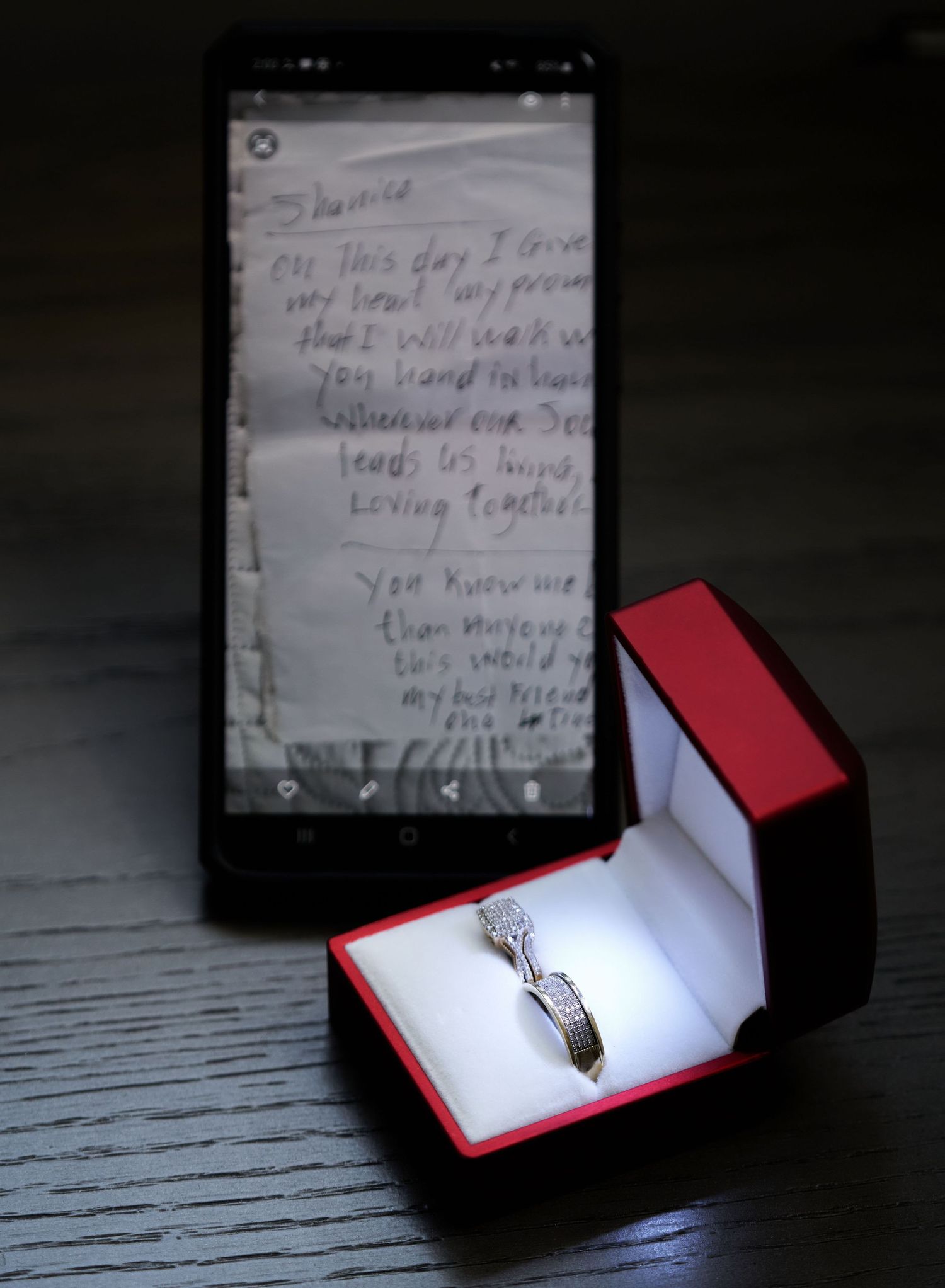 A beautiful engagement ring in a red jewelry box displayed from multiple angles against a weathered wooden surface.