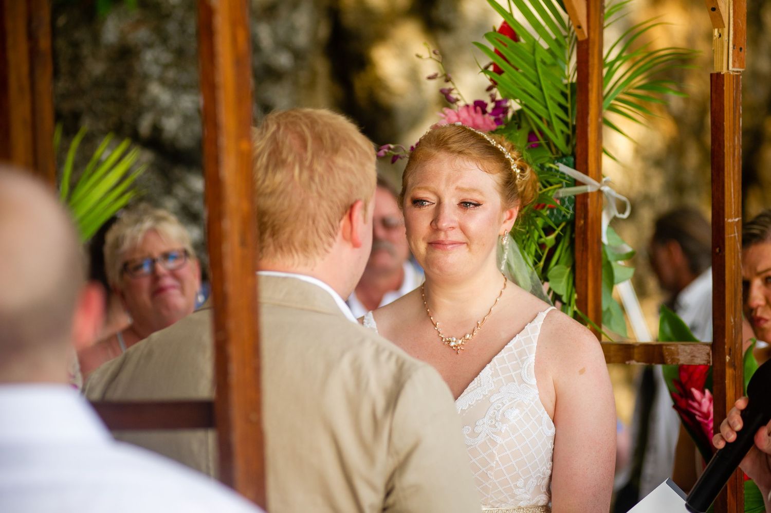 Indoor wedding celebration in a rustic wooden venue with tropical palm decor.