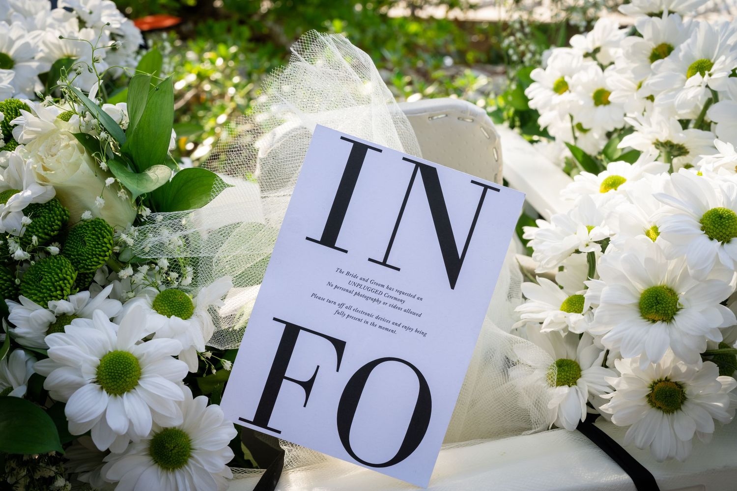 Fresh white daisies arranged with elegant typography on printed wedding invitations.