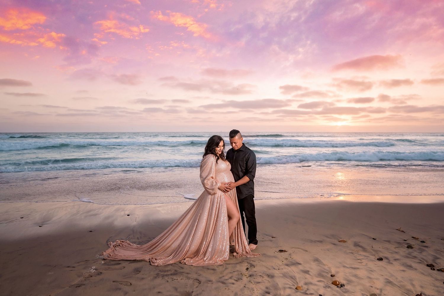 Dreamy maternity beach portraits at golden hour with pink sunset sky and crashing waves. San Diego Maternity Photographer