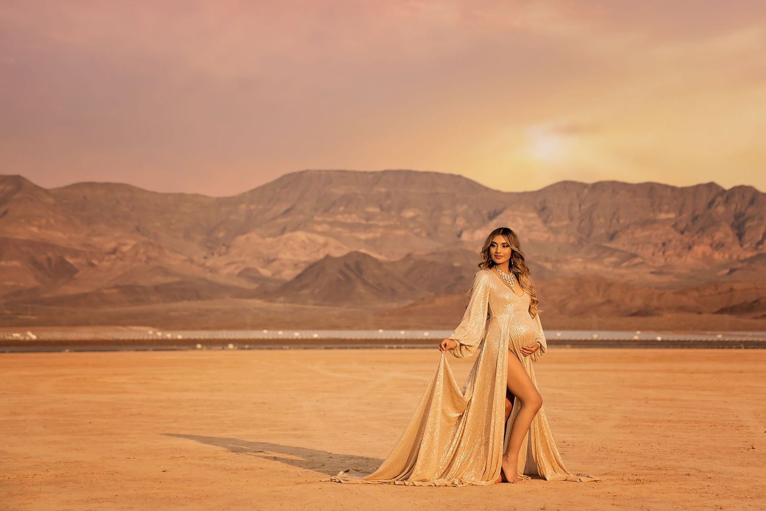 Ethereal desert maternity photography with flowing champagne fabric at sunset.