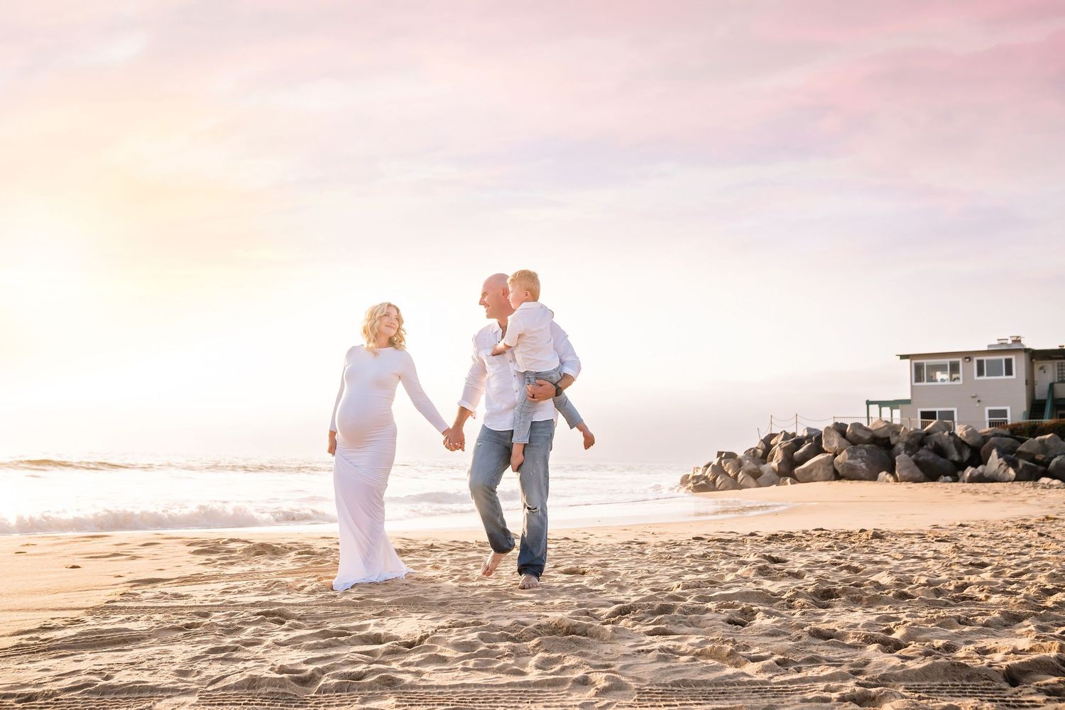 Casual beach maternity photoshoot with white outfits against golden sunset. San Diego Maternity Photographer