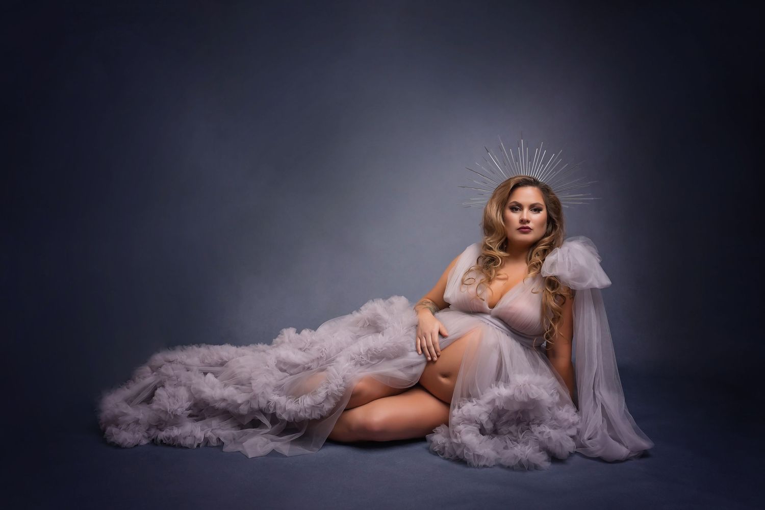 Maternity portrait with grey flowing dress and decorative crown headpiece