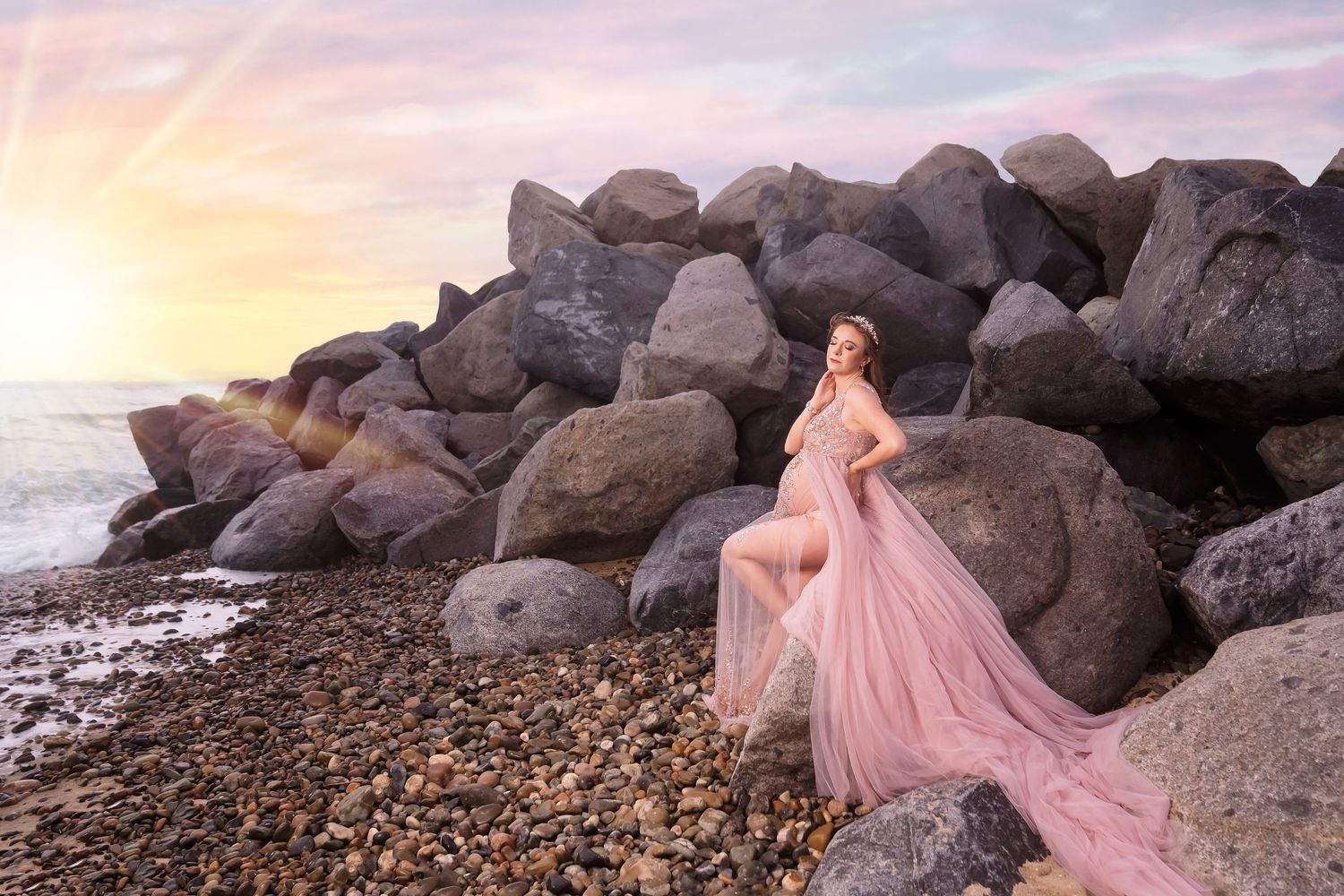Maternity photo session at rocky beach during sunset with flowing pink dress. San Diego Maternity Photographer
