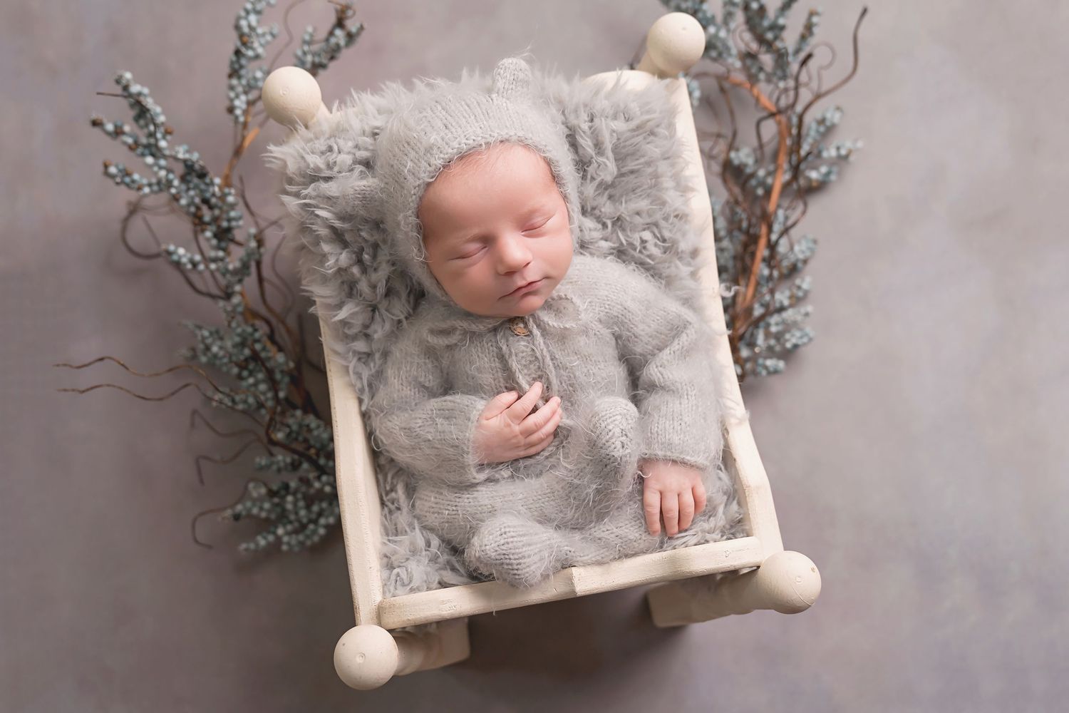 Winter themed newborn session with white knit textures and silver branches. San Diego Newborn Photographer