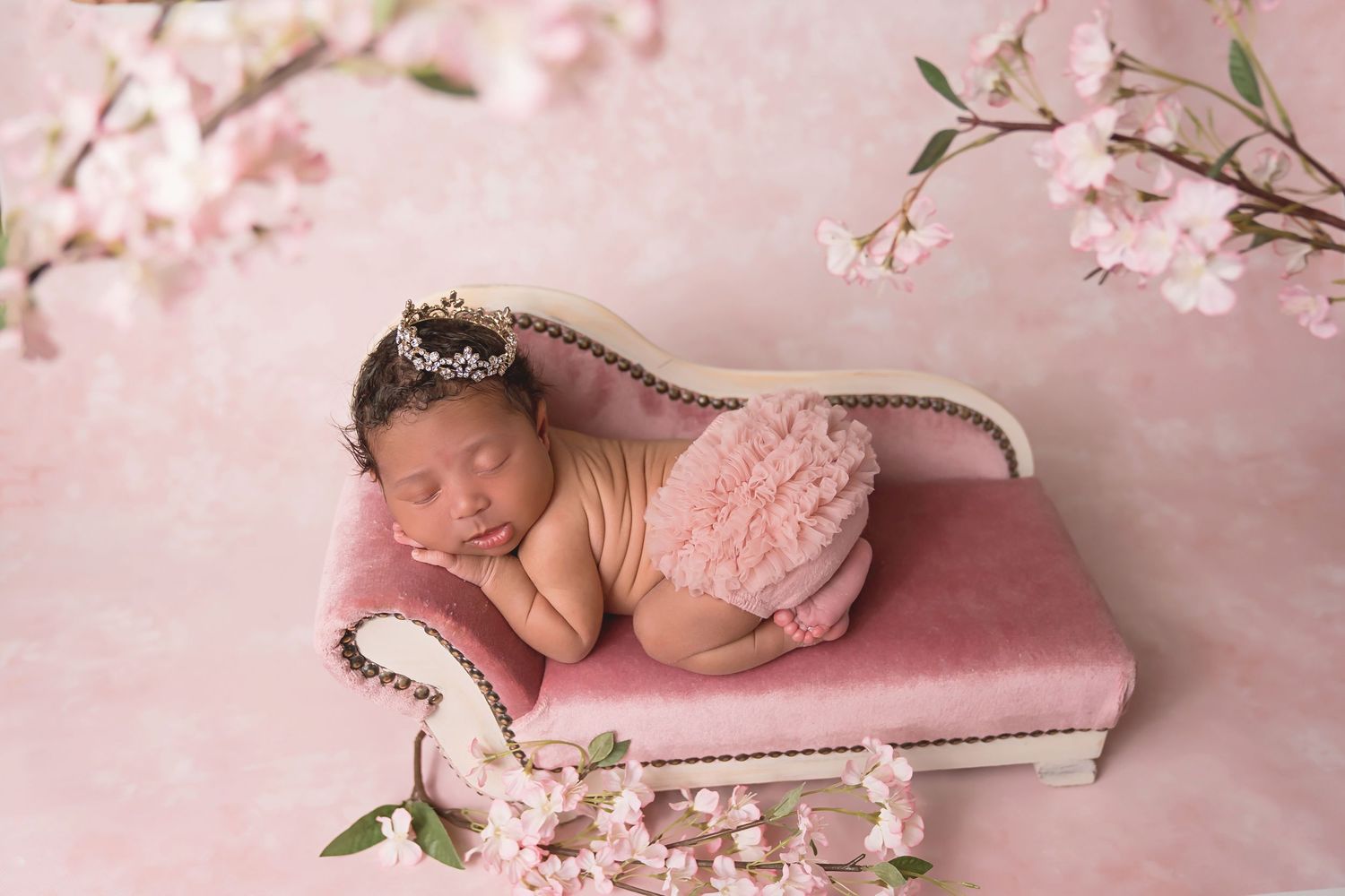Dreamy newborn photography setup with cherry blossoms and pink tones. San Diego Newborn Photographer