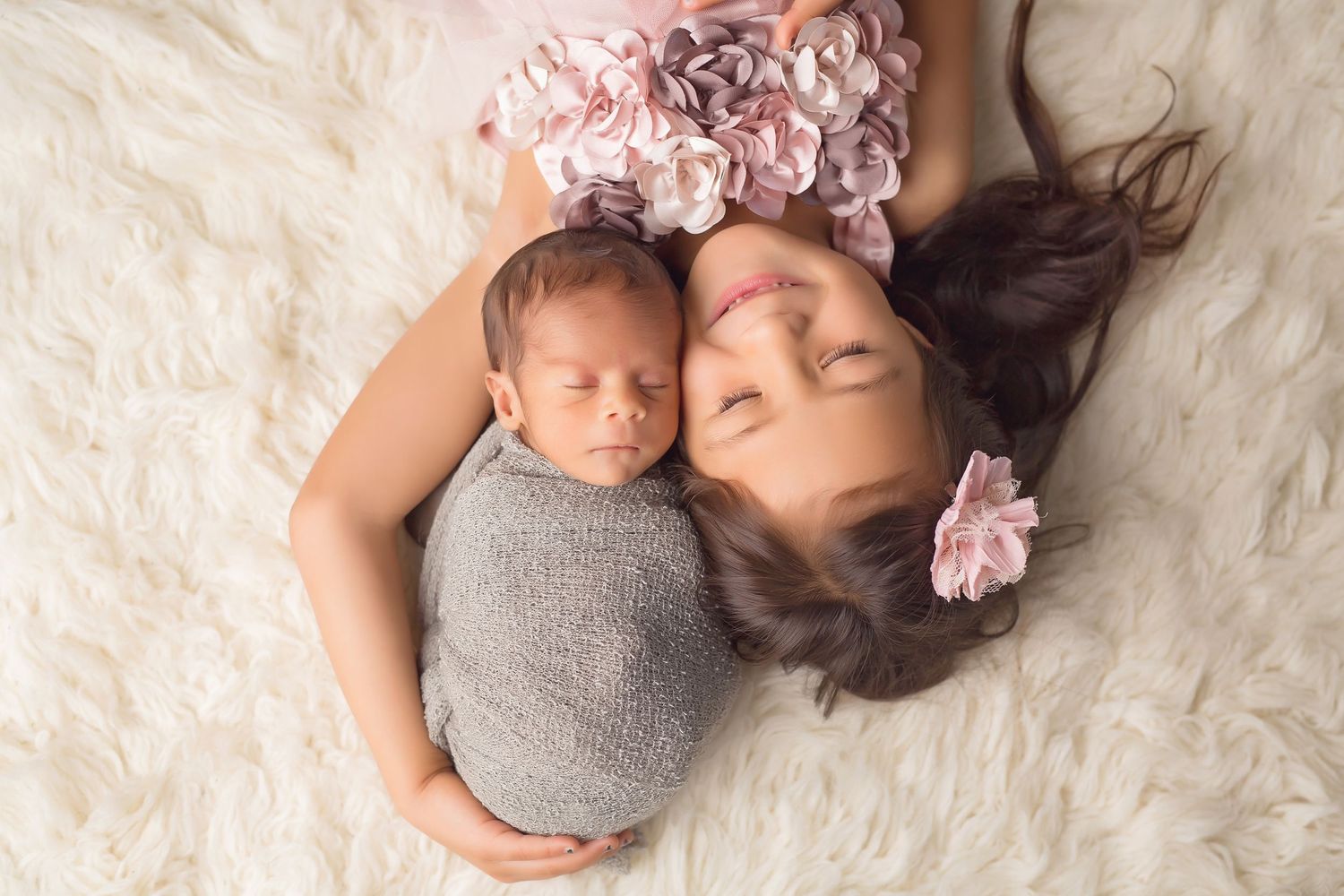 San Diego newborn photographer captures newborn baby with big sister laying peacefully on a fluffly rug