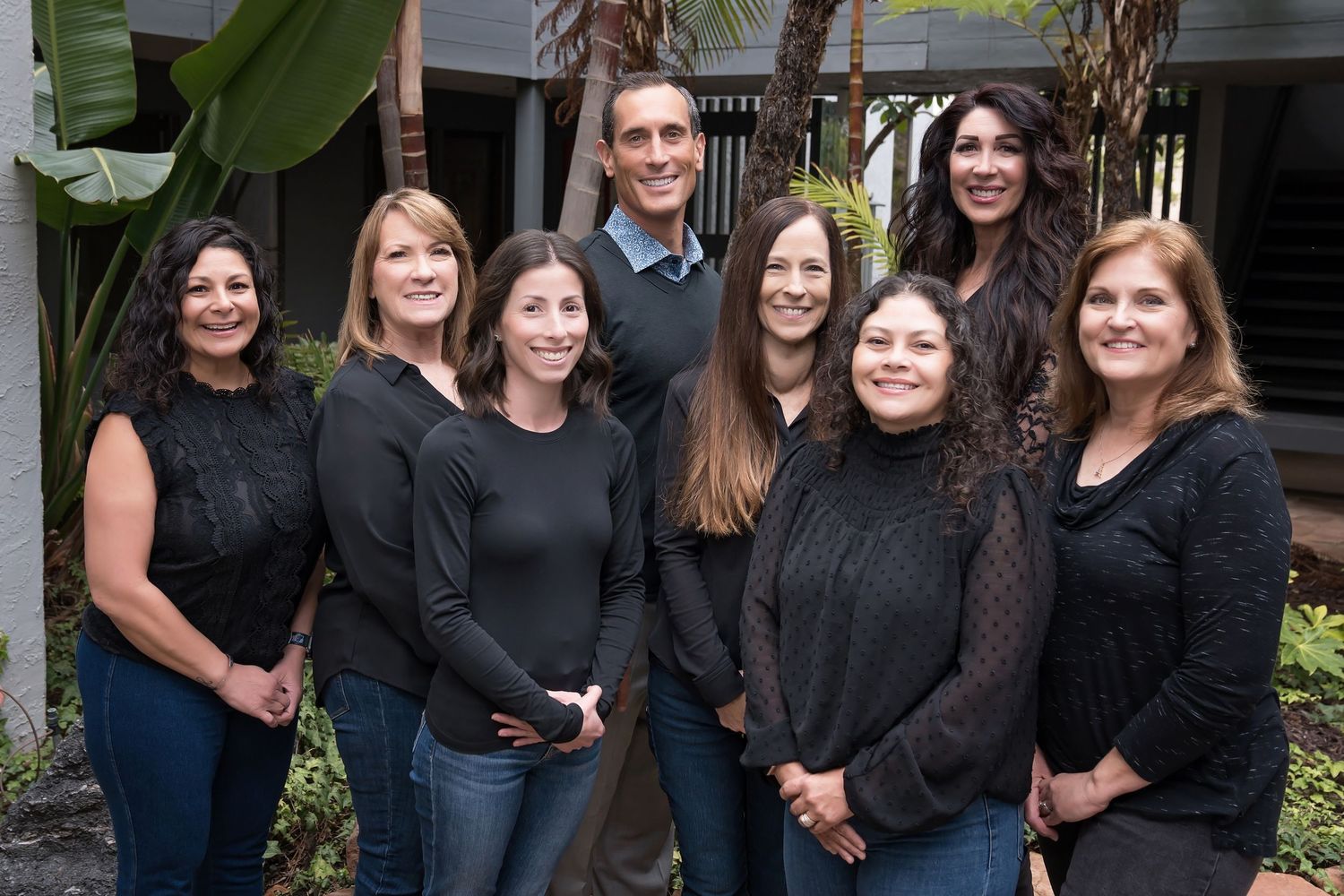 Outdoor group portrait of team members wearing coordinated black outfits