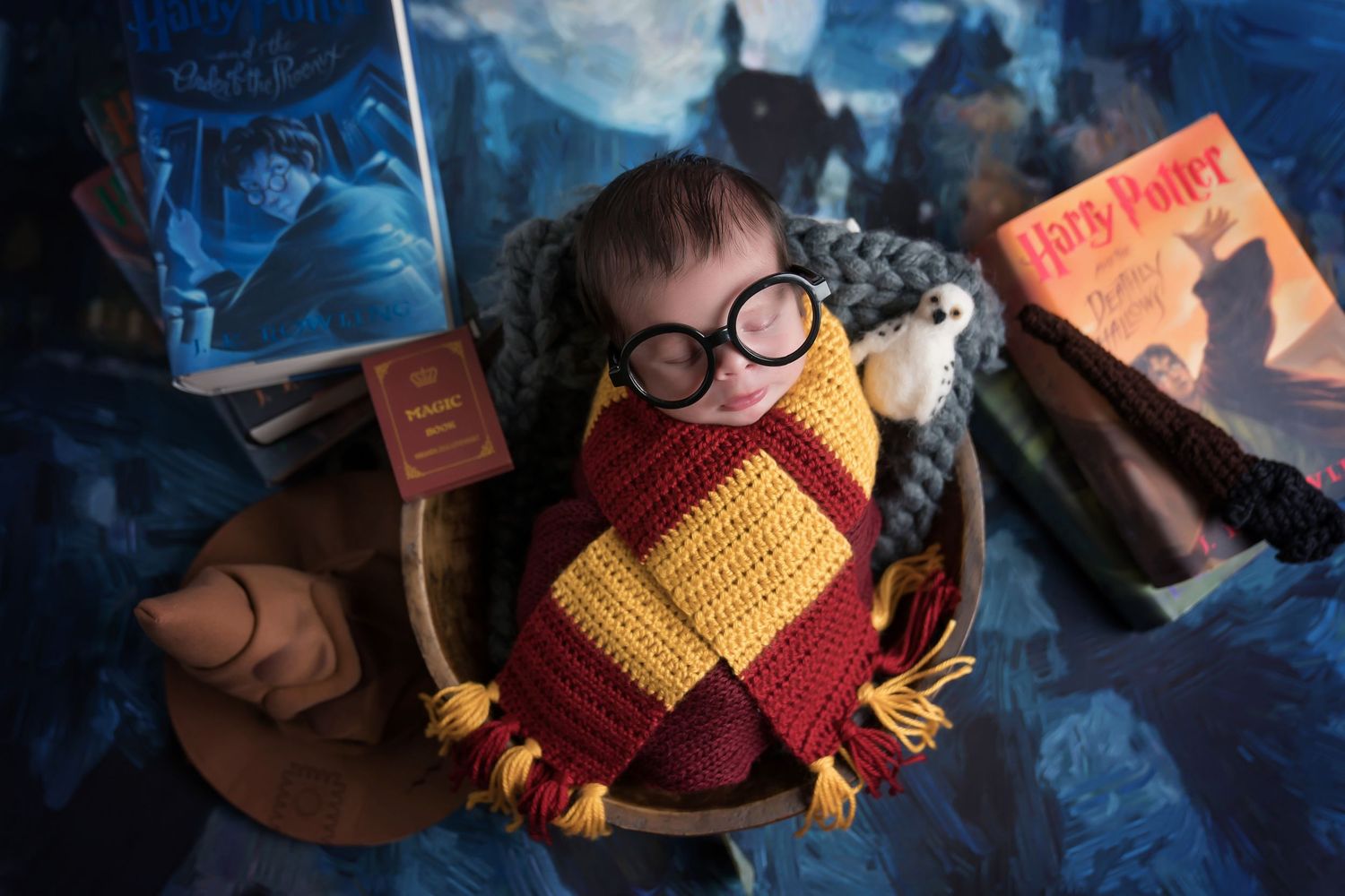 Harry Potter themed newborn setup with Gryffindor scarf and magical castle backdrop. San Diego Newborn Photographer