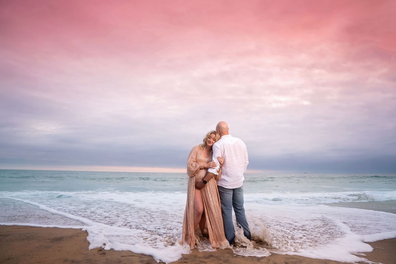 maternity photos in Dramatic coastal landscape with waves crashing against rocks during sunset. San Diego Maternity Photographer