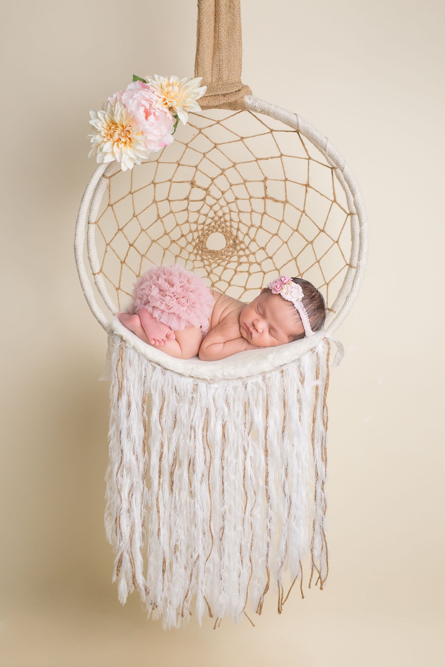 Newborn baby sleeping peacefully in decorative white macrame hanging basket with tassels. San Diego Newborn Photographer