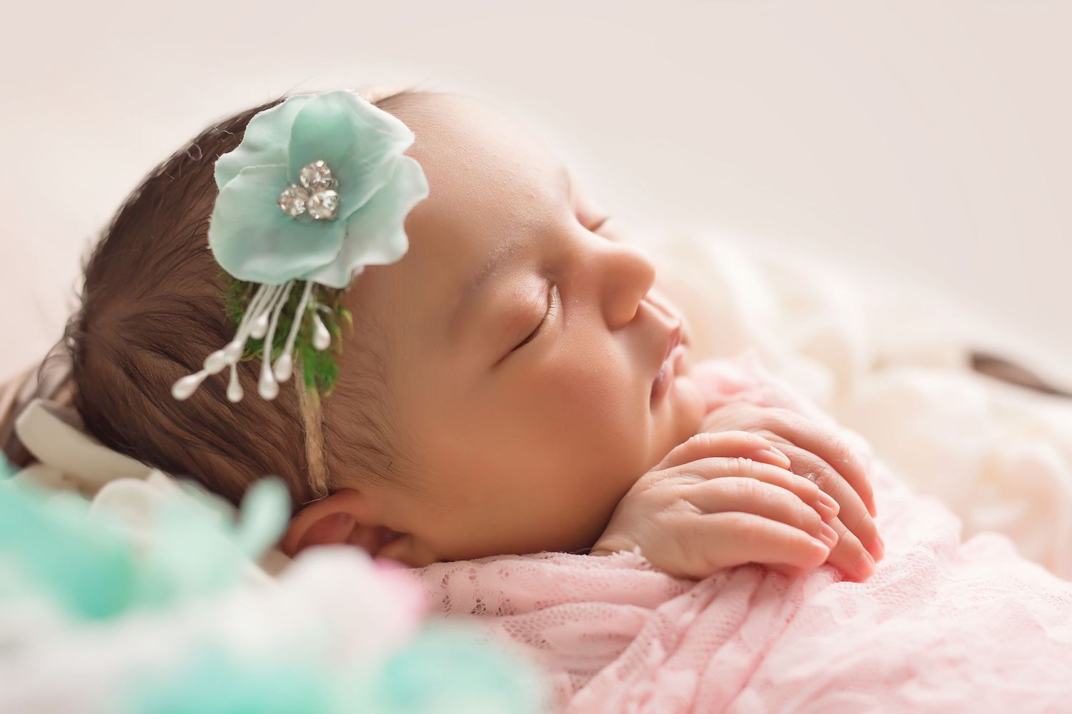San Diego newborn photographer captures Newborn baby sleeping peacefully in pink and mint green floral setting