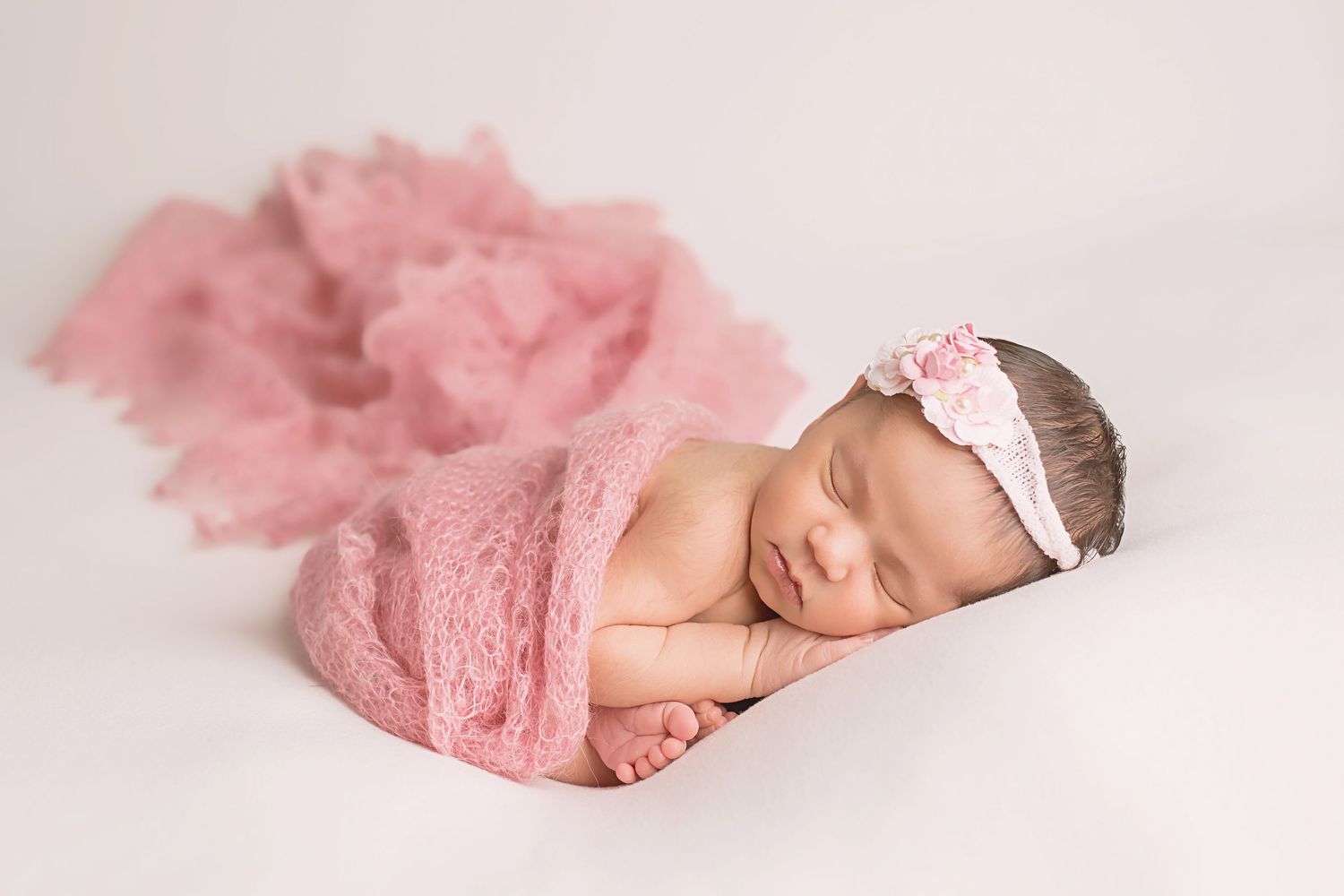 Sleeping newborn wearing pink tutu and headband in artistic photography setup. San Diego Newborn Photographer