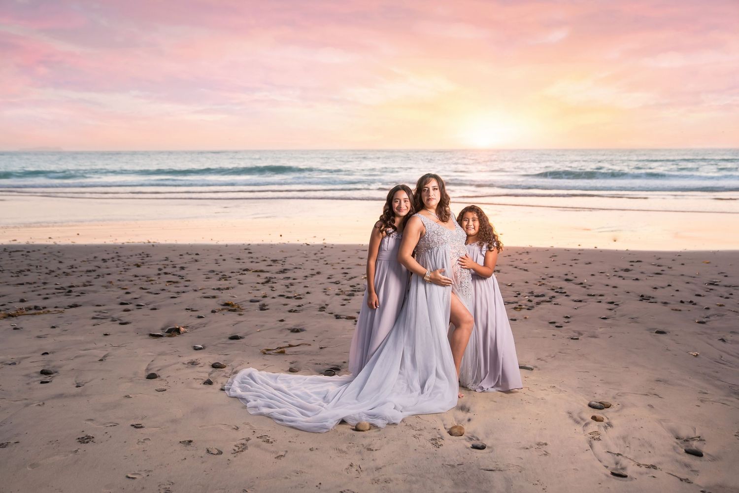 Beach maternity session with flowing white dresses against ocean backdrop at sunset. San Diego Maternity Photographer