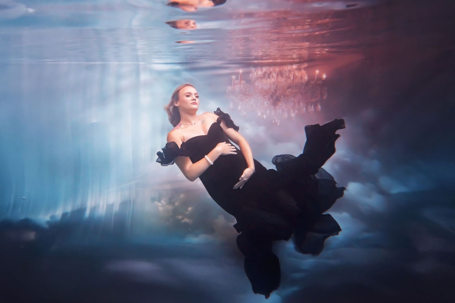 San Diego Underwater photography of a pregnant woman with Dramatic flowing black dress against moody blue