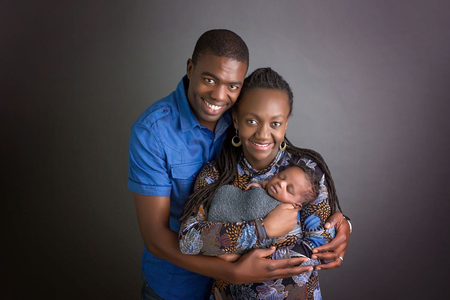 Sweet family moment captured in studio against dark background. San Diego Newborn Photographer