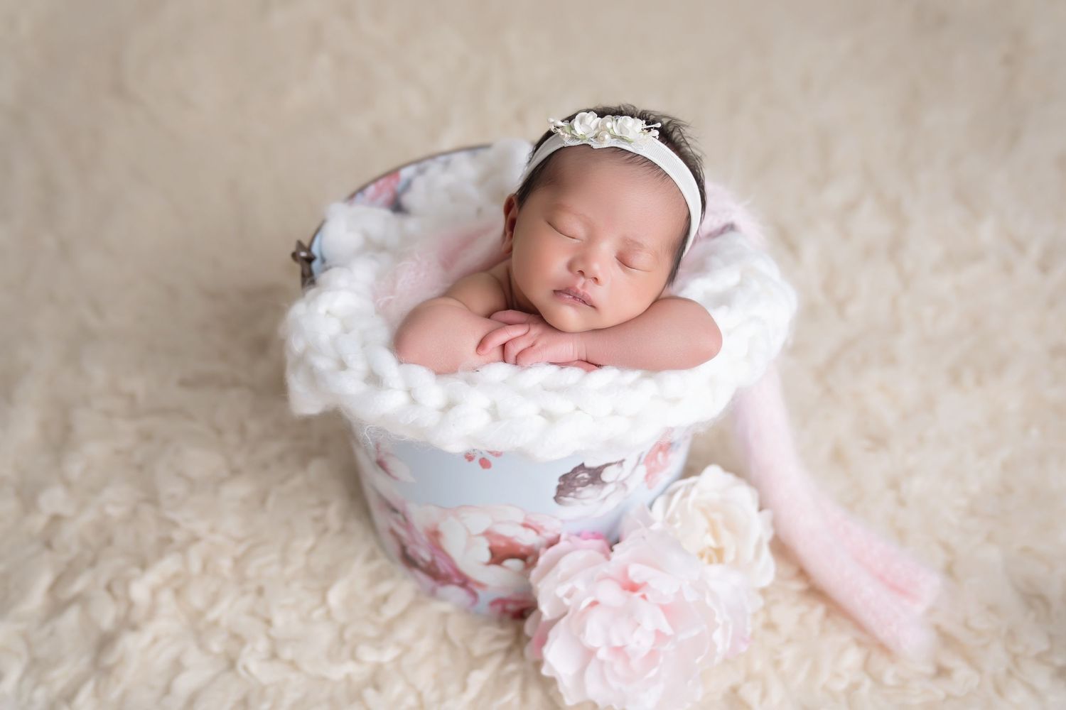 Newborn sleeping on pink floral cushion with delicate lace details. San Diego Newborn Photographer