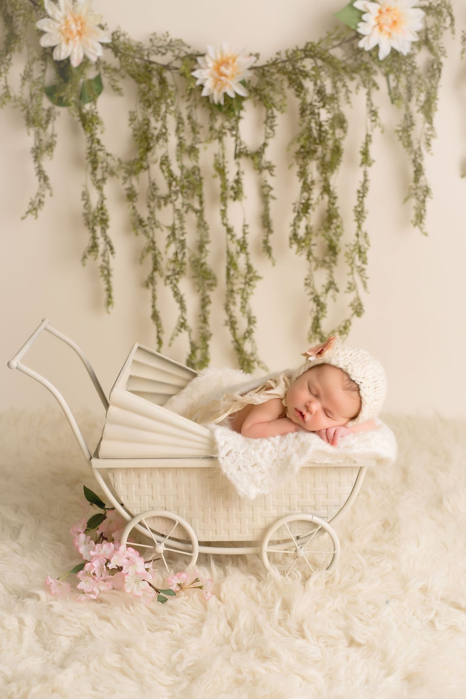 Vintage pram with floral decorations and sleeping newborn in dreamy nursery setting. San Diego Newborn Photographer