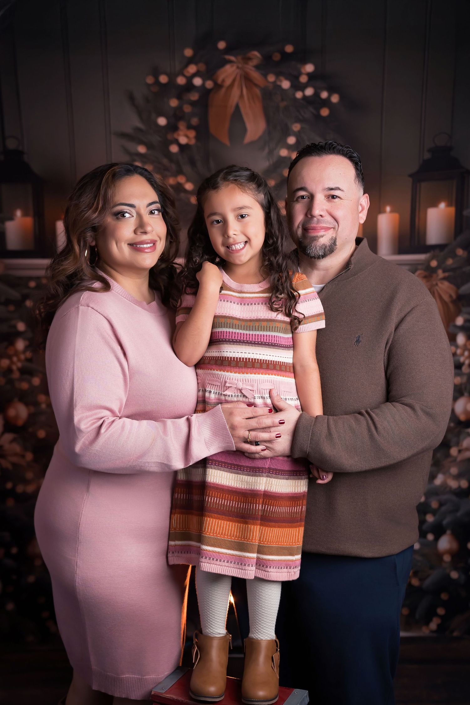 San diego Holiday Mini Session. Cozy family holiday portrait in front of a decorated fireplace with glowing lanterns and festive wreath.
