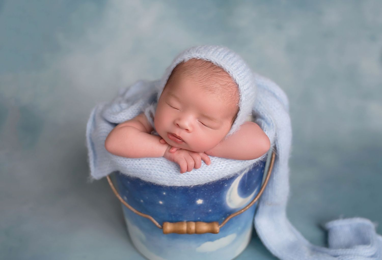 Dreamy newborn photography with blue moon prop and celestial theme. San Diego Newborn Photographer