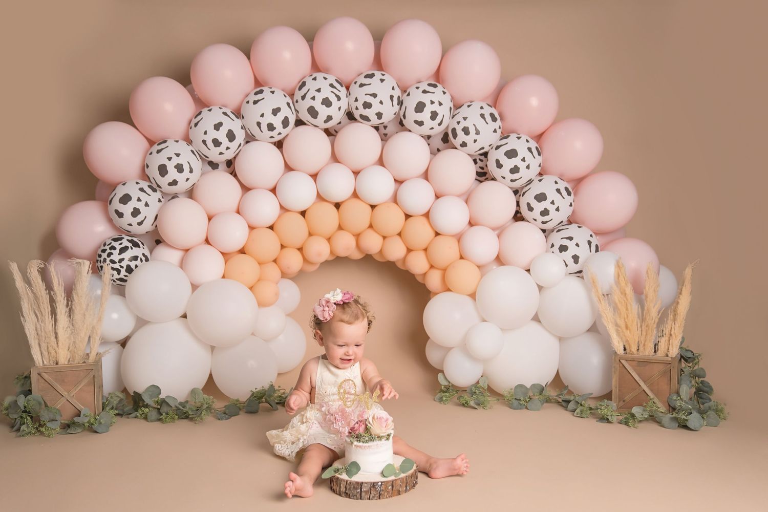 Elegant balloon arch in blush pink tones with decorative white accents. San Diego cake smash photographer