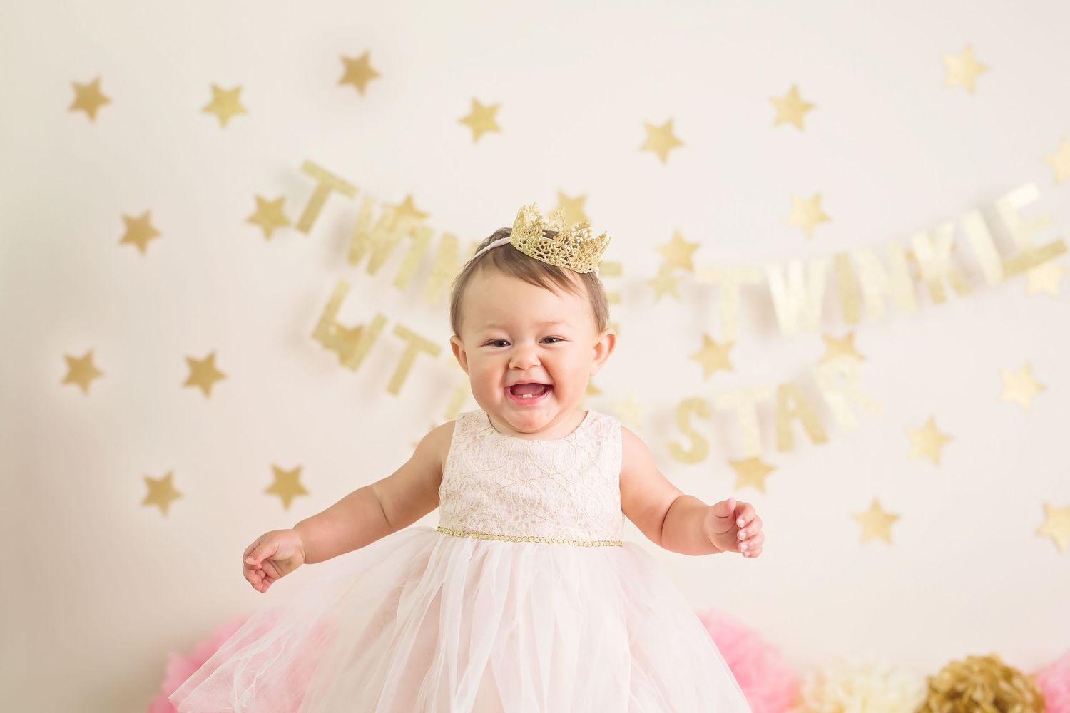 Whimsical photo setup with gold stars and pink decor against white backdrop. San Diego cake smash photographer