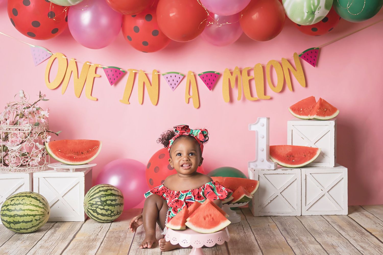 Watermelon themed cake smash setup with pink backdrop and decorative balloon garland. San Diego cake smash photographer
