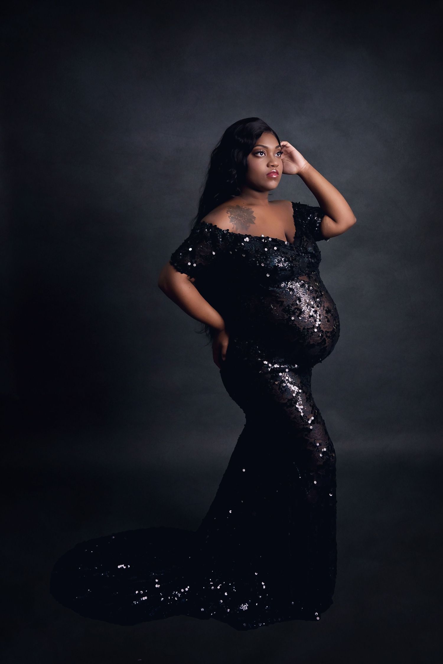 Glamorous maternity portrait in black sequin gown with dramatic train.