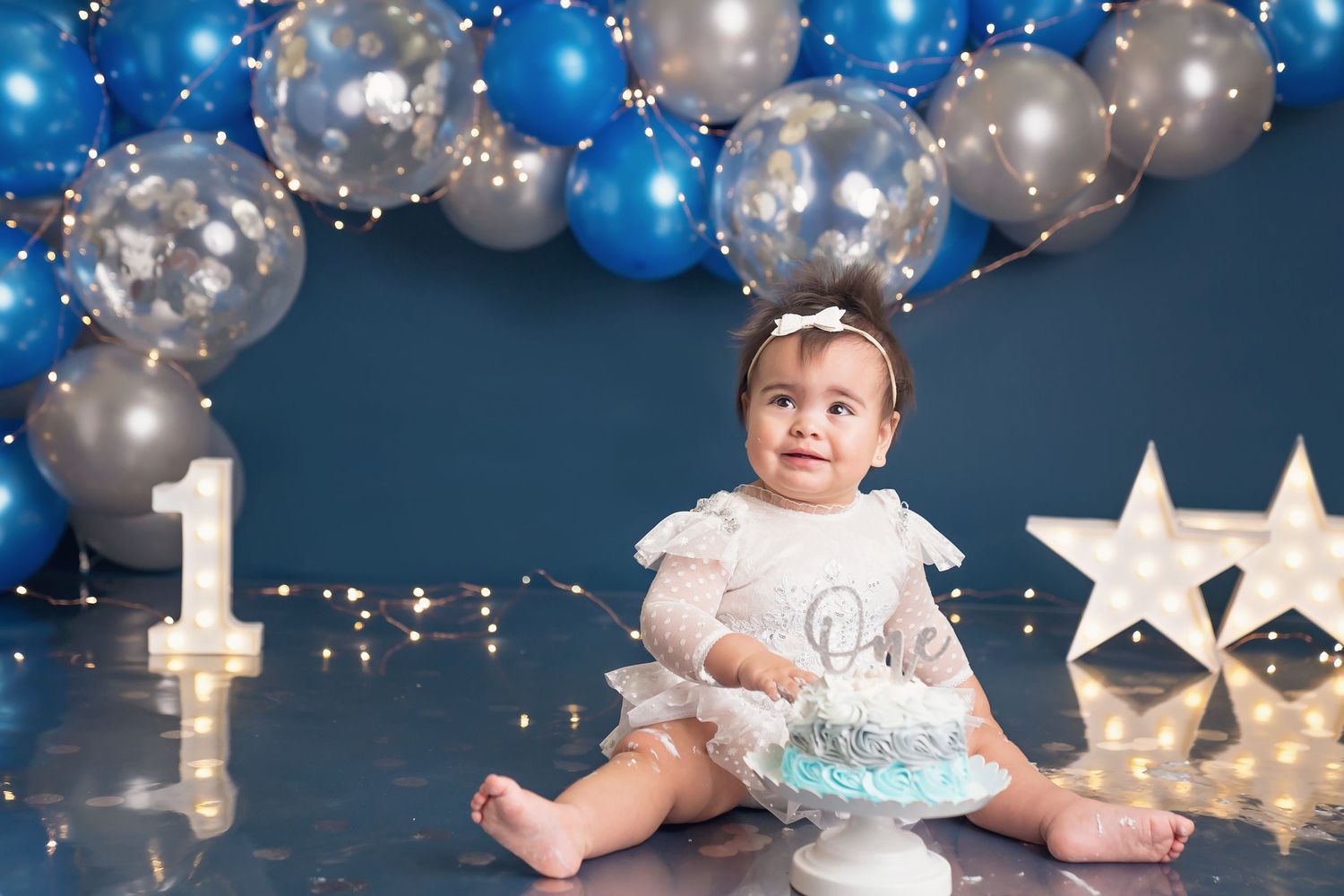 Elegant birthday setup featuring blue and silver balloons with glowing star decorations.