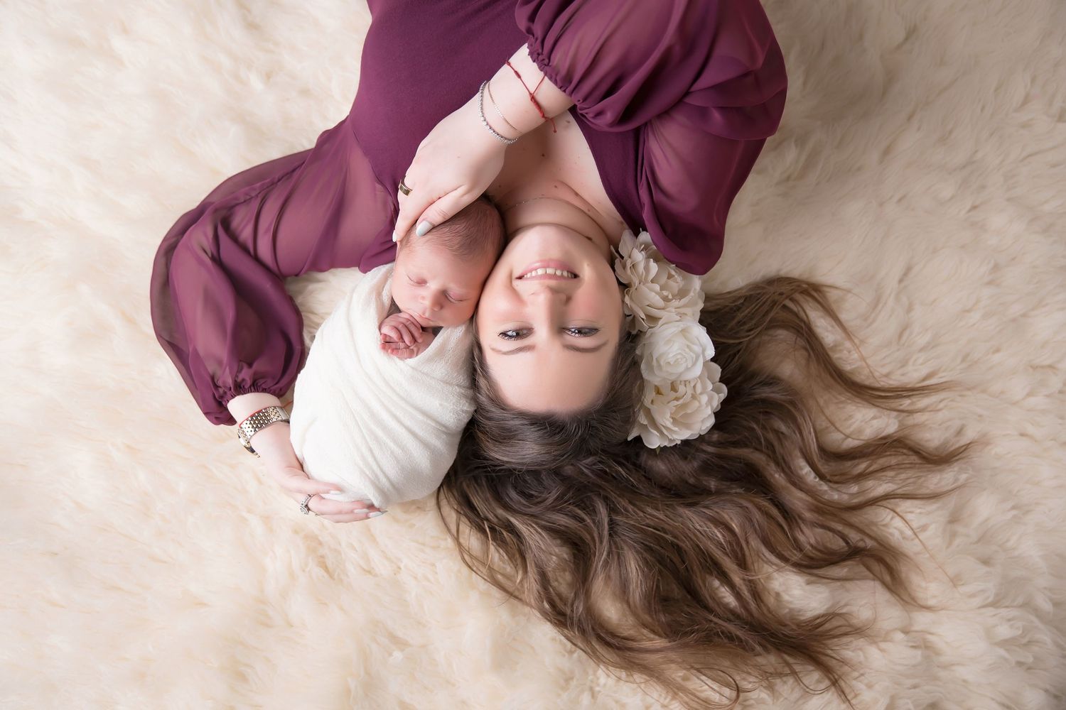 Artistic maternity photos in burgundy dress on cream colored background showing flowing fabric. San Diego Newborn Photographer