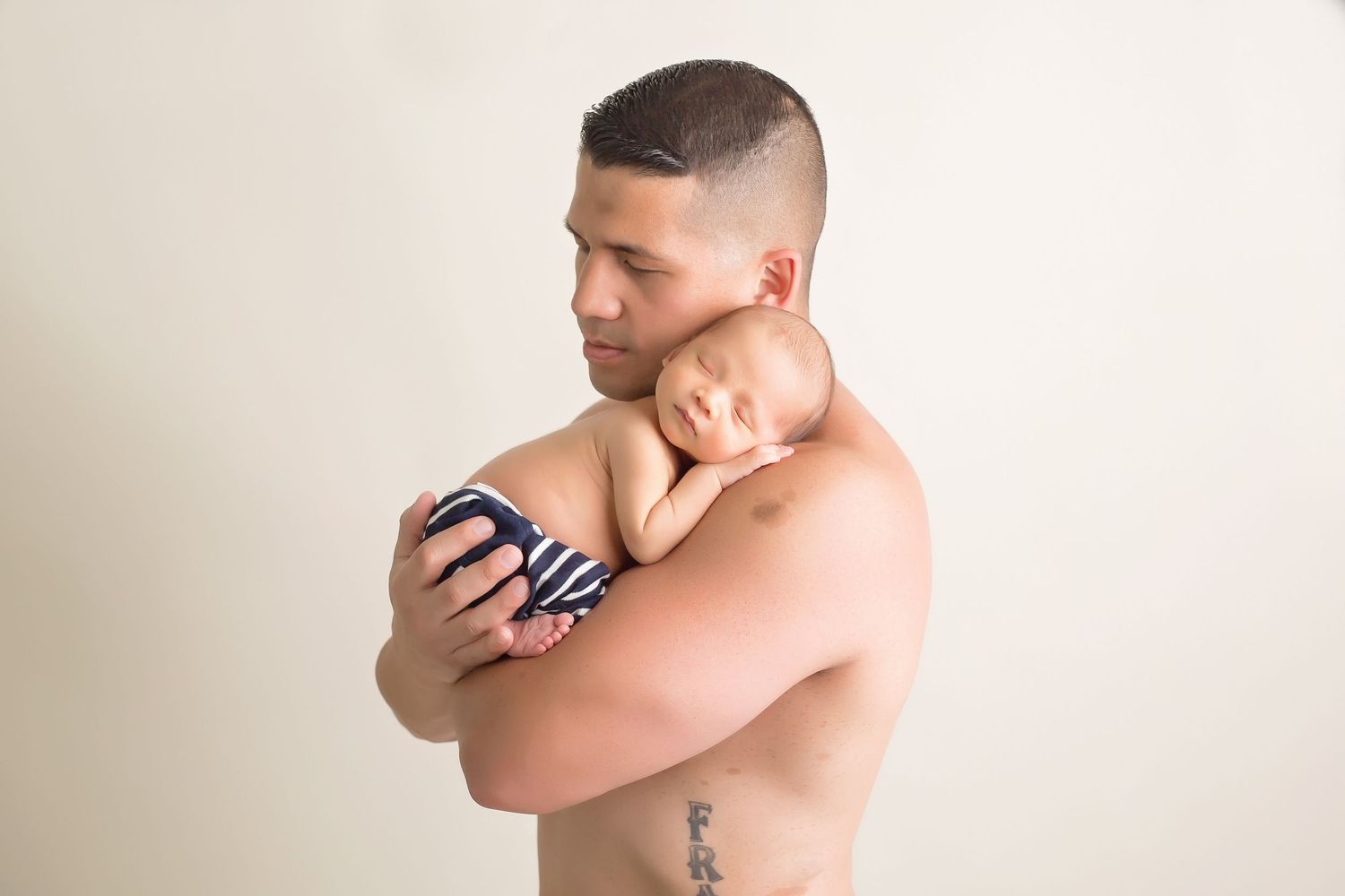 father holding newborn baby during professional photoshoot. San Diego Newborn Photographer