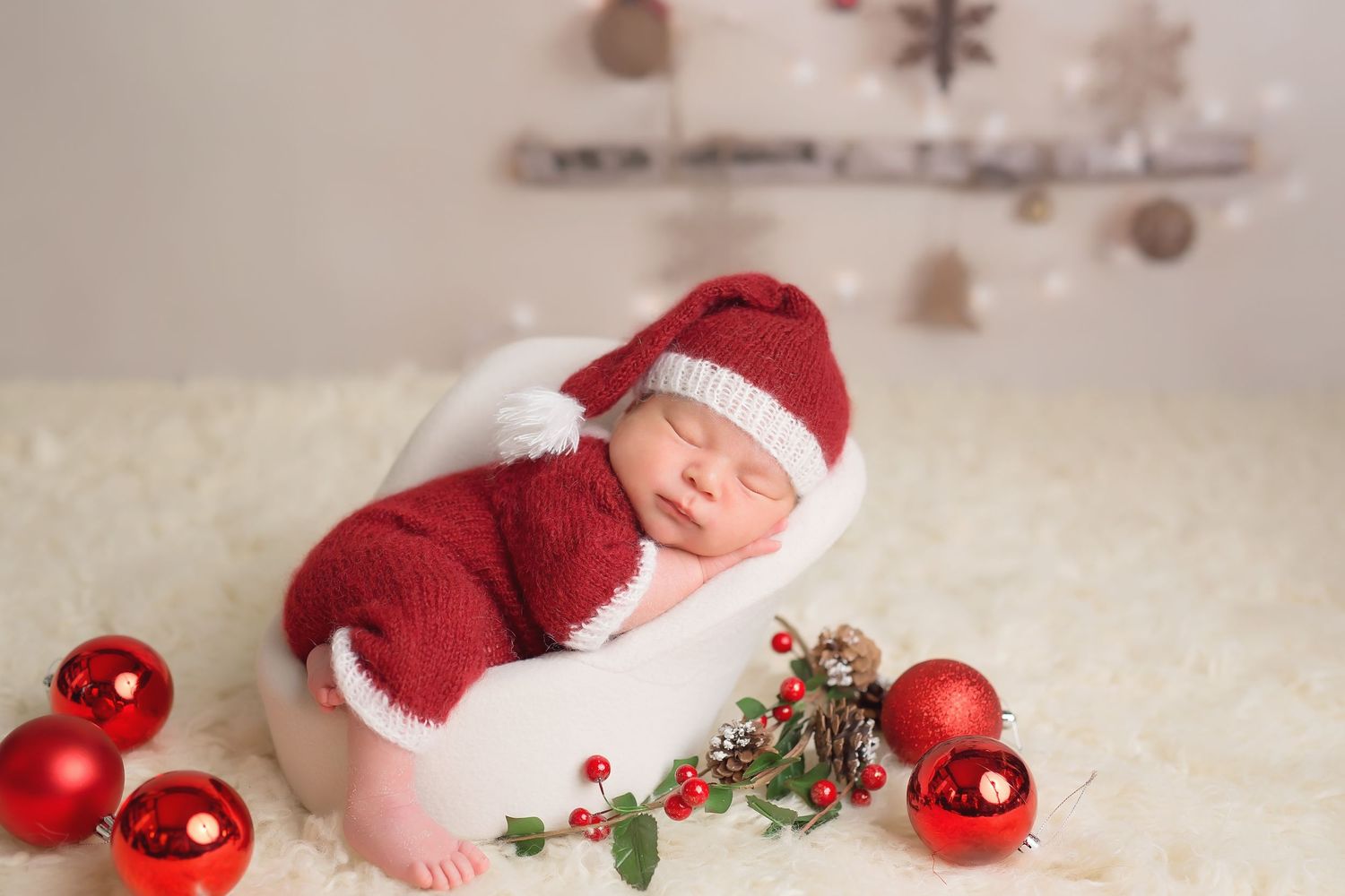 Holiday themed newborn photo with red Christmas ornaments and festive decorations. San Diego Newborn Photographer