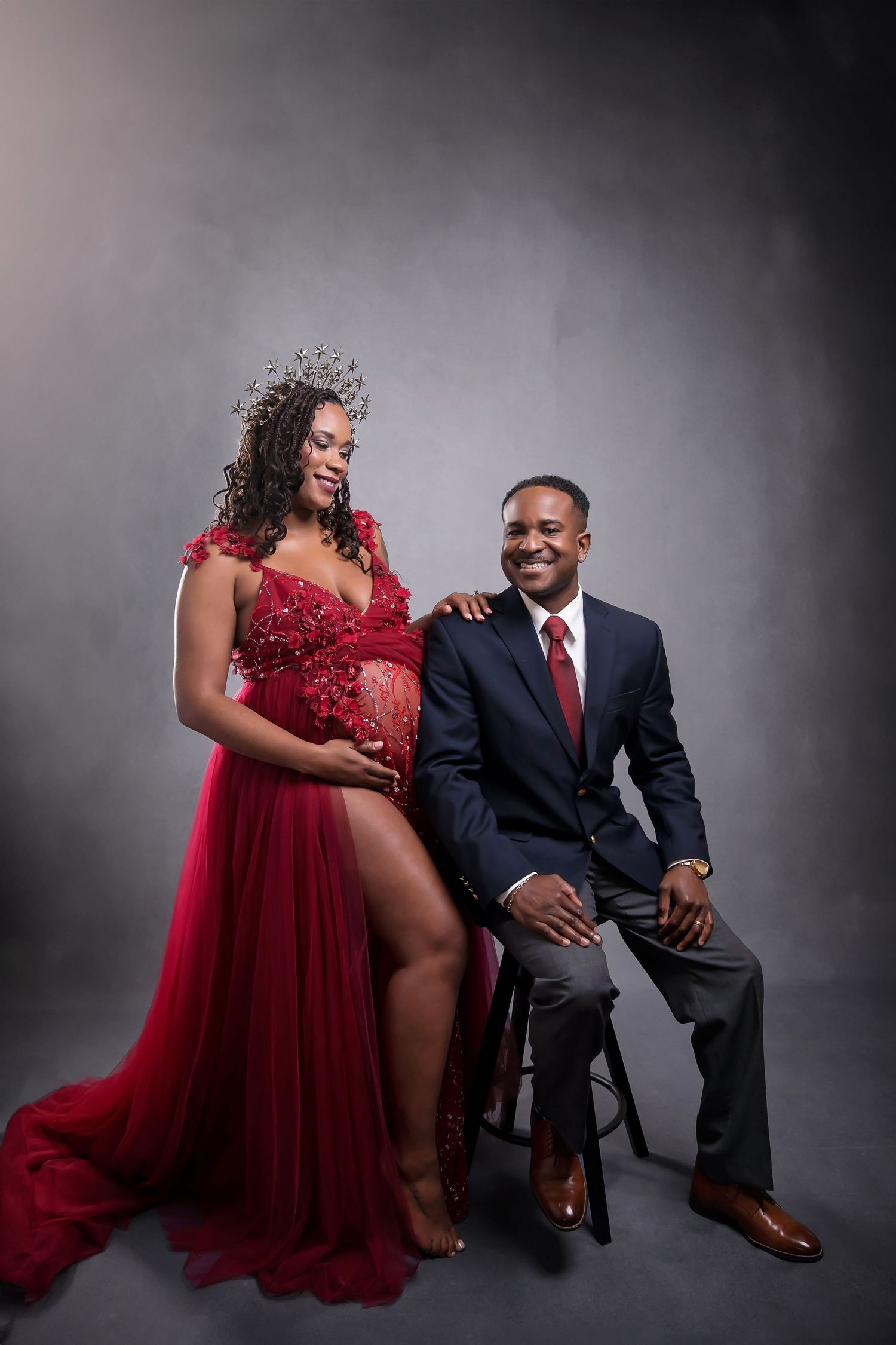 Romantic maternity couple portrait with red gown and formal black suit — San Diego studio session