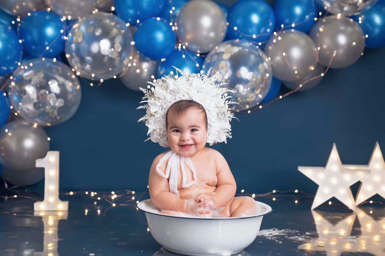Birthday photo setup with twinkling lights, balloons and illuminated star decorations.