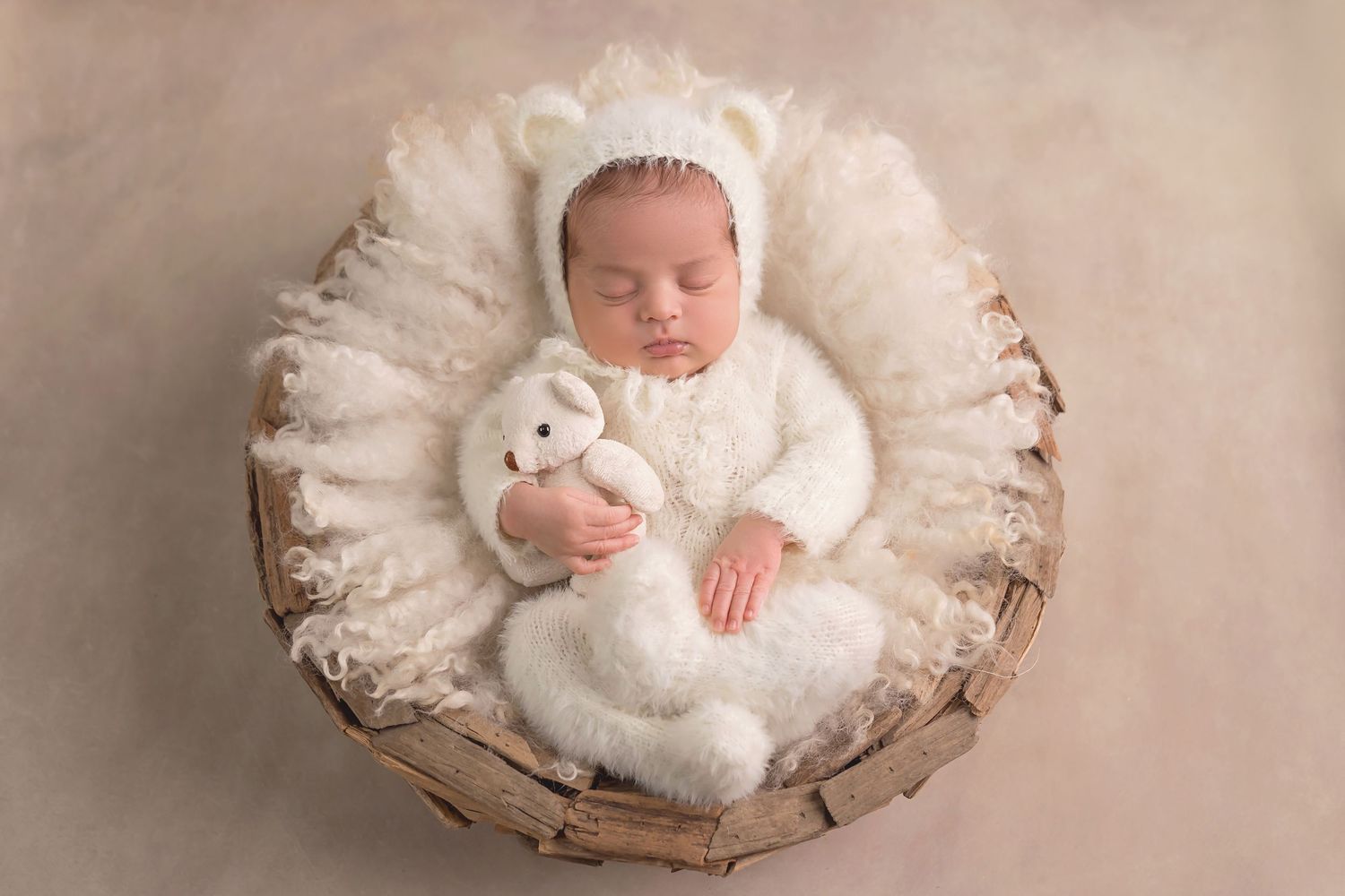 San Diego newborn photographer captures Cozy newborn photography setup with white plush textures and soft lighting.