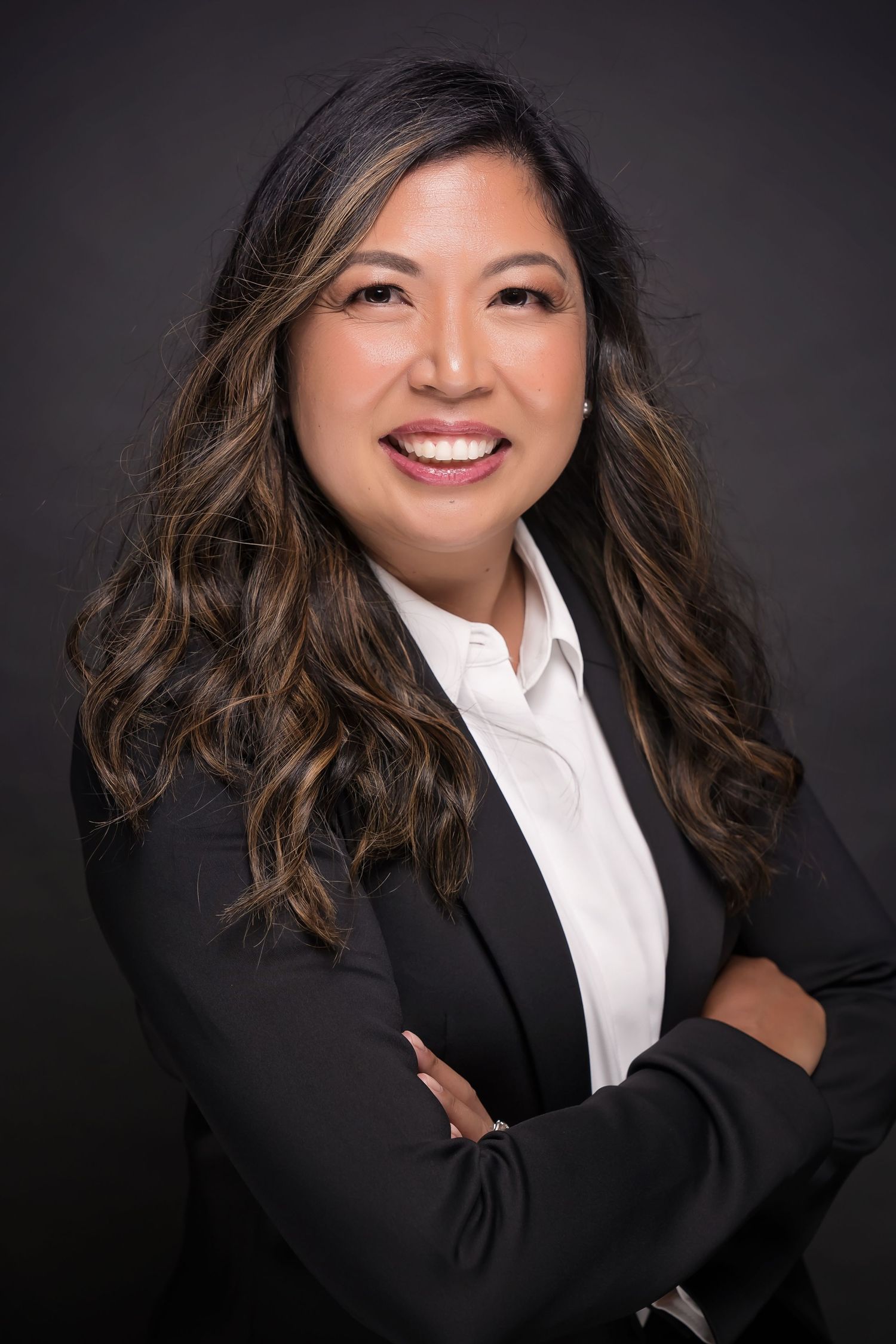 Professional headshot featuring woman in black blazer and white shirt with dynamic posing