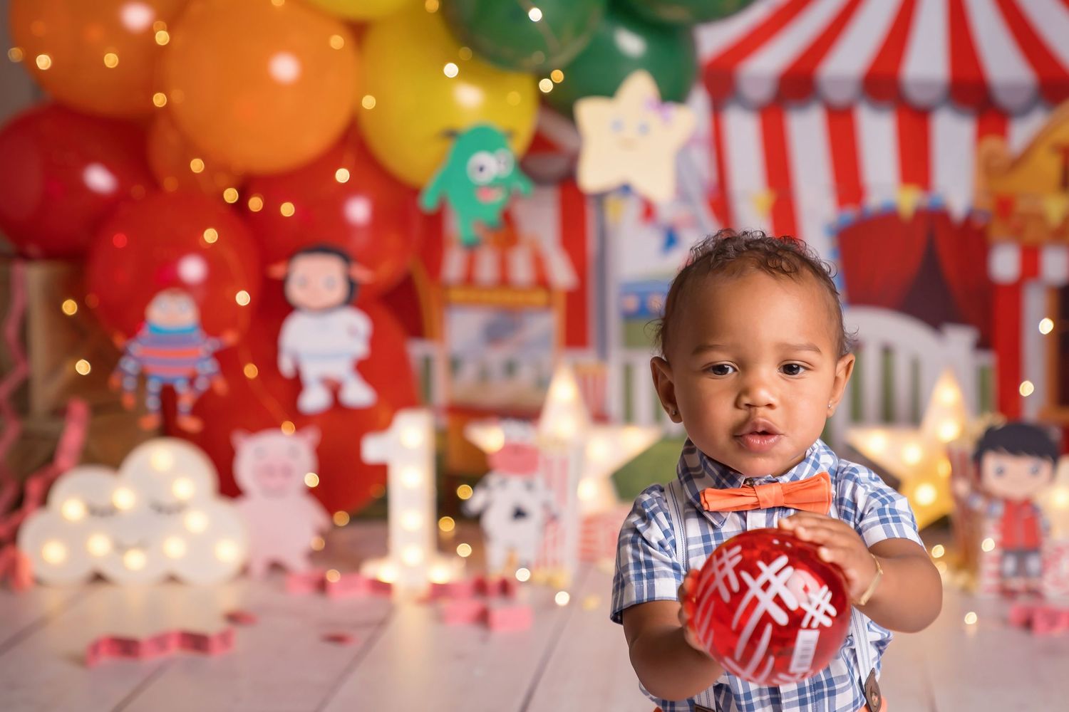 Carnival-themed photography setup with rainbow balloons and circus tent backdrop.
