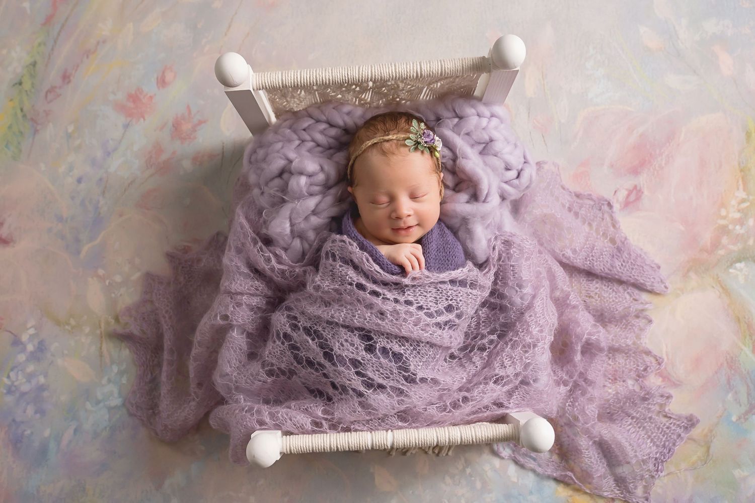 Purple lace wrap and white bed create ethereal newborn photography scene. San Diego Newborn Photographer