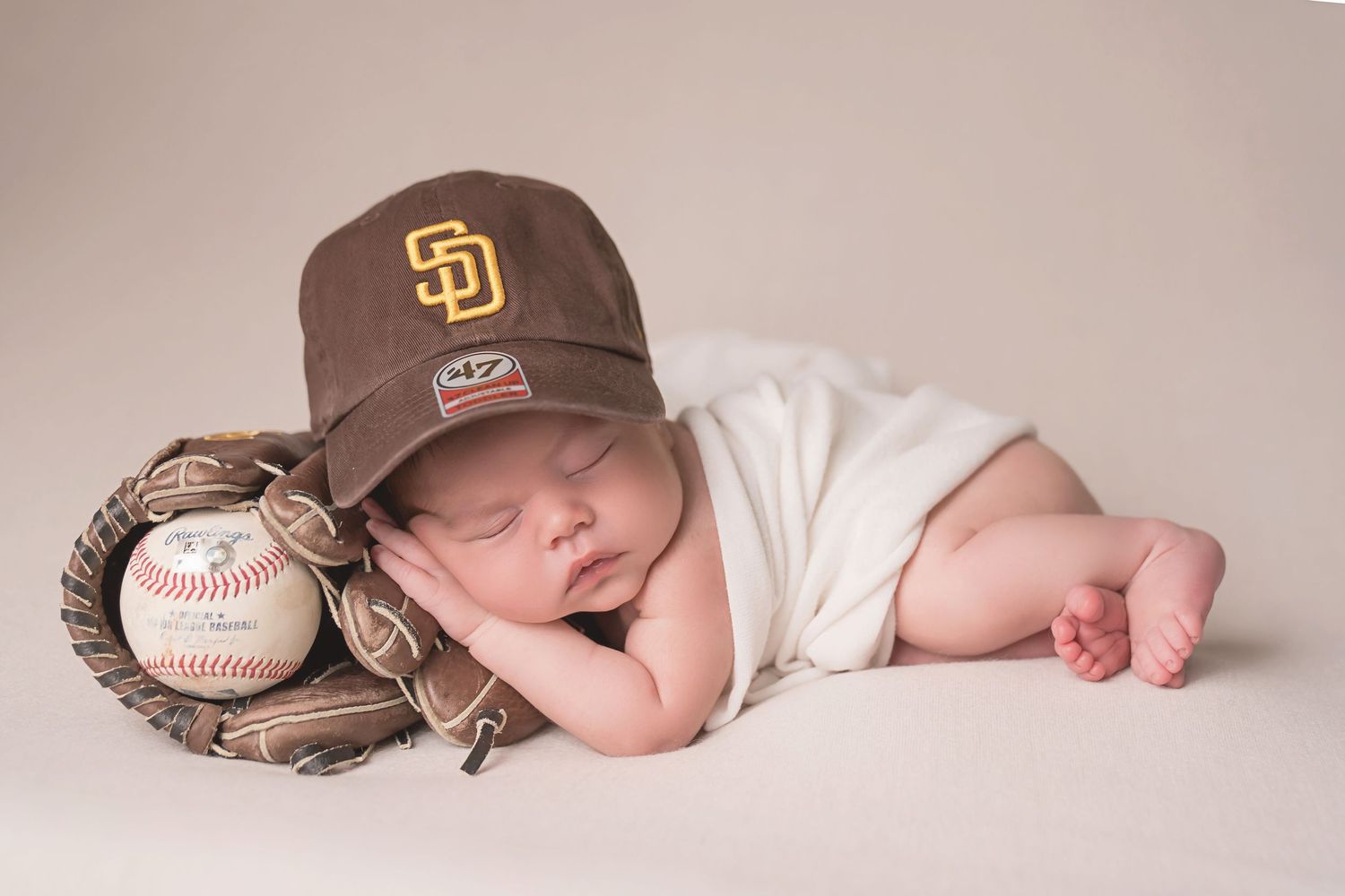 San Diego newborn photographer captures san diego padres themed newborn photography with San Diego Padres cap and baseball equipment.