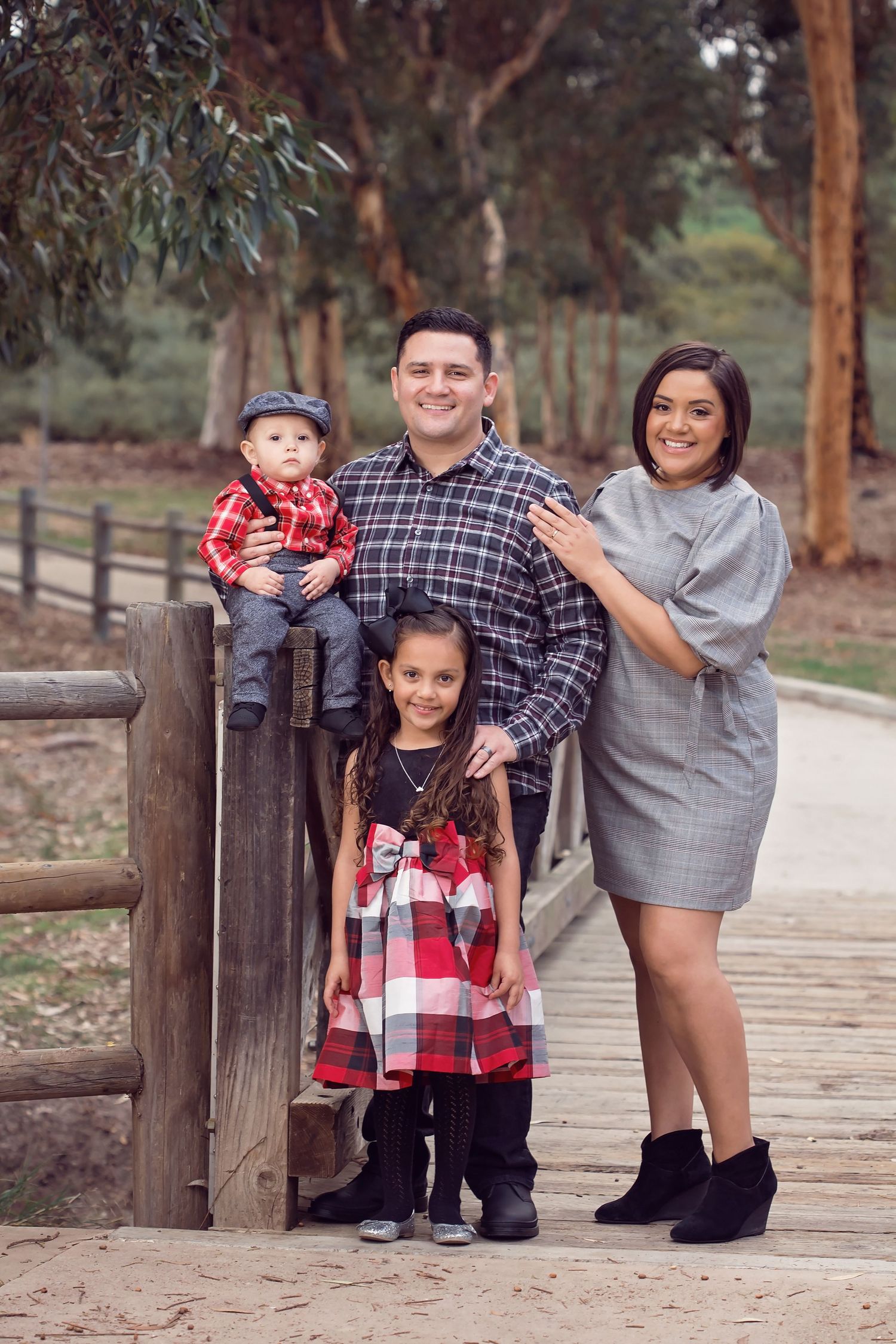 Family members lined up along a wooden fence during a playful outdoor portrait session